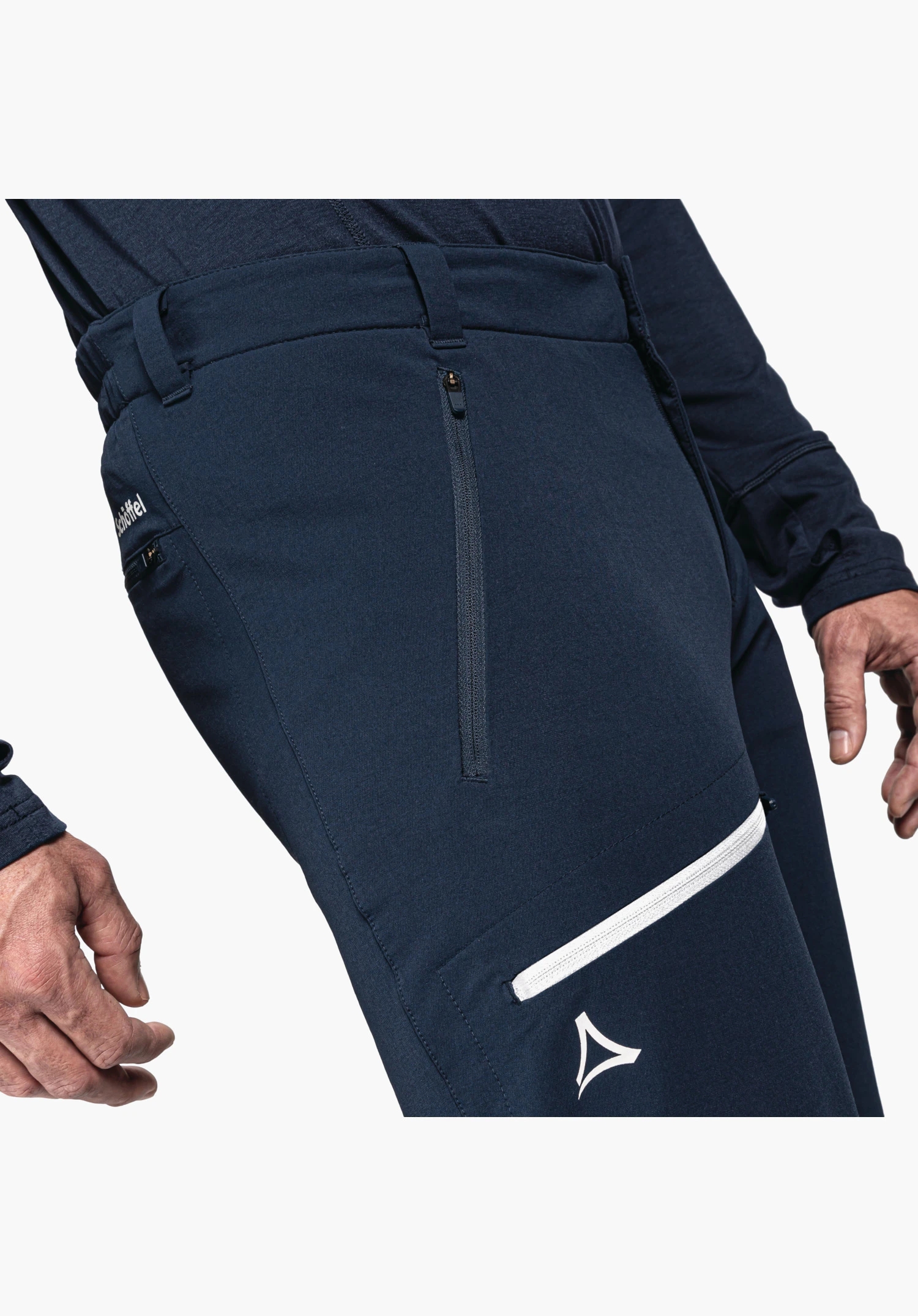 Pants Folkstone Warm M shows the thigh pocket with white zip and the Schöffel logo on the blue fabric, close-up against a neutral background.