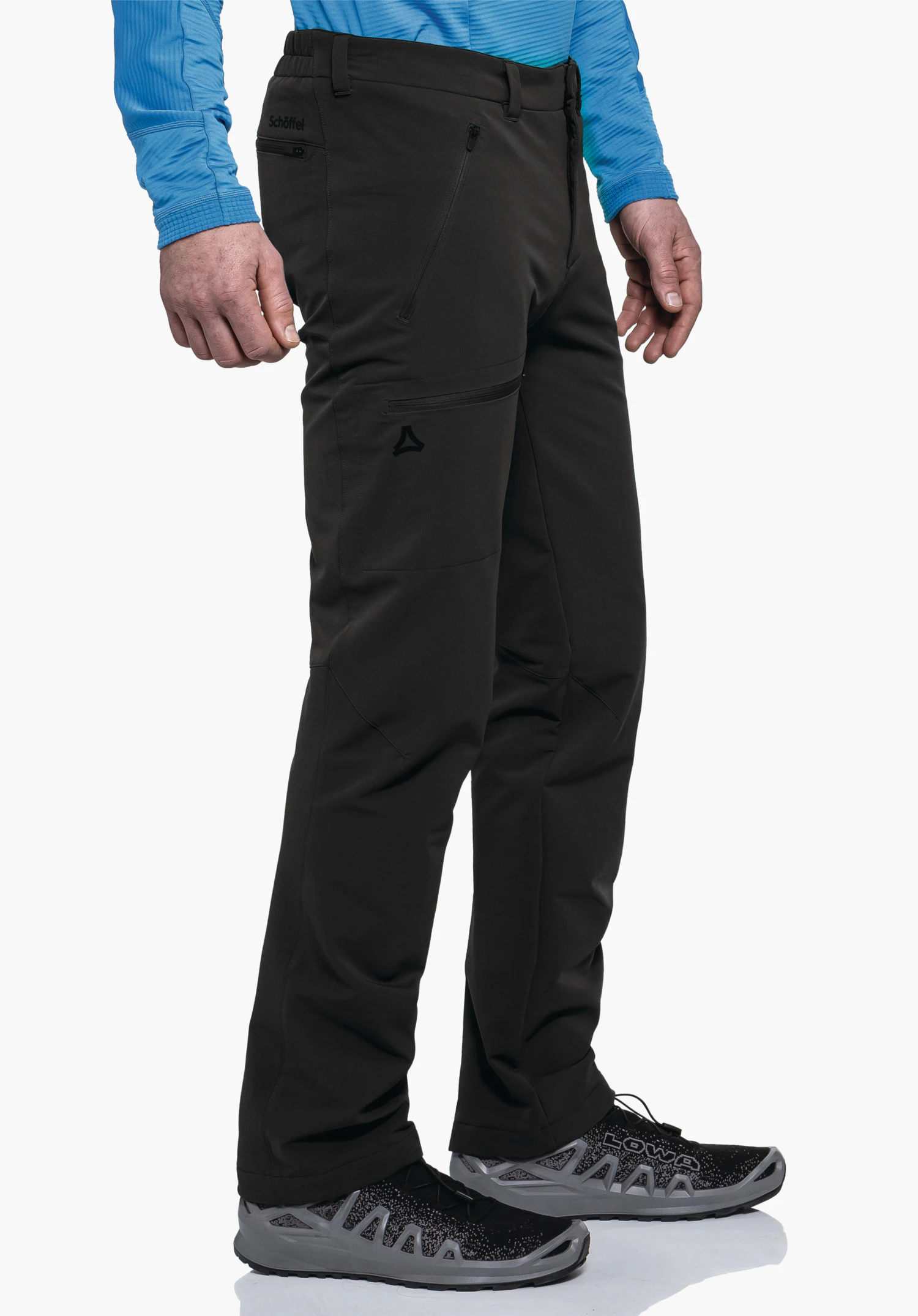 Pants Folkstone Warm M black outdoor trousers worn by a standing person; Schöffel logo on the thigh, lettering "Schöffel" on the waistband, shoe text "LOWA"; light blue top, white background., Pants Folkstone Warm M black outdoor trousers worn by a standing person; Schöffel logo on the thigh, lettering "Schöffel" on the waistband, shoe text "LOWA"; light blue top, white background.