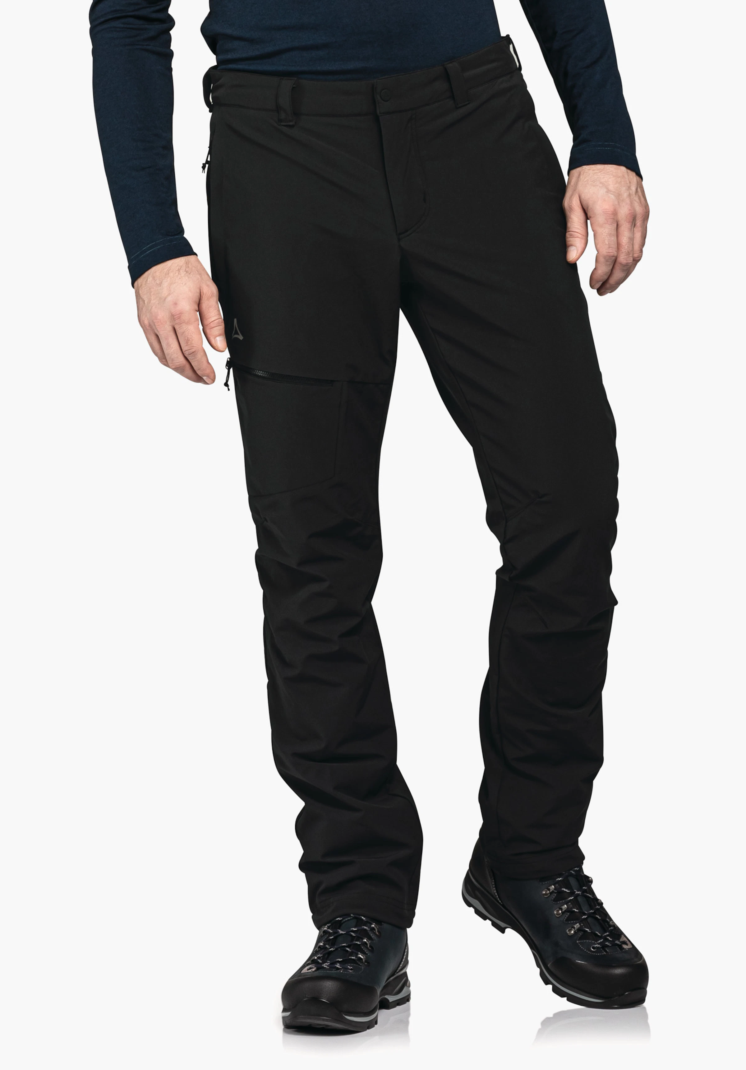 Pants Koper1 Warm M Black outdoor trousers worn by a standing person, with Schöffel logo on the left thigh, zip pocket; combined with a dark blue top and black hiking shoes against a white background.