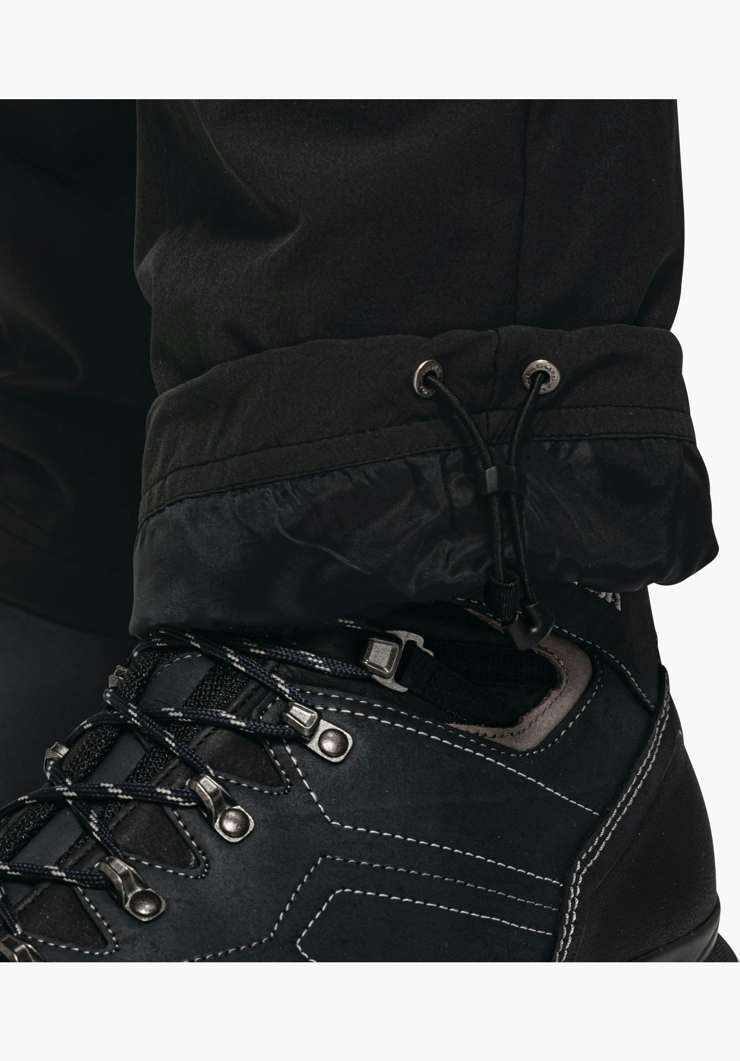 Pants Koper1 Warm M, verstellbarer Beinsaum mit Kordelzug und Stopper in Schwarz, Detailaufnahme vor weißem/neutralem Hintergrund.