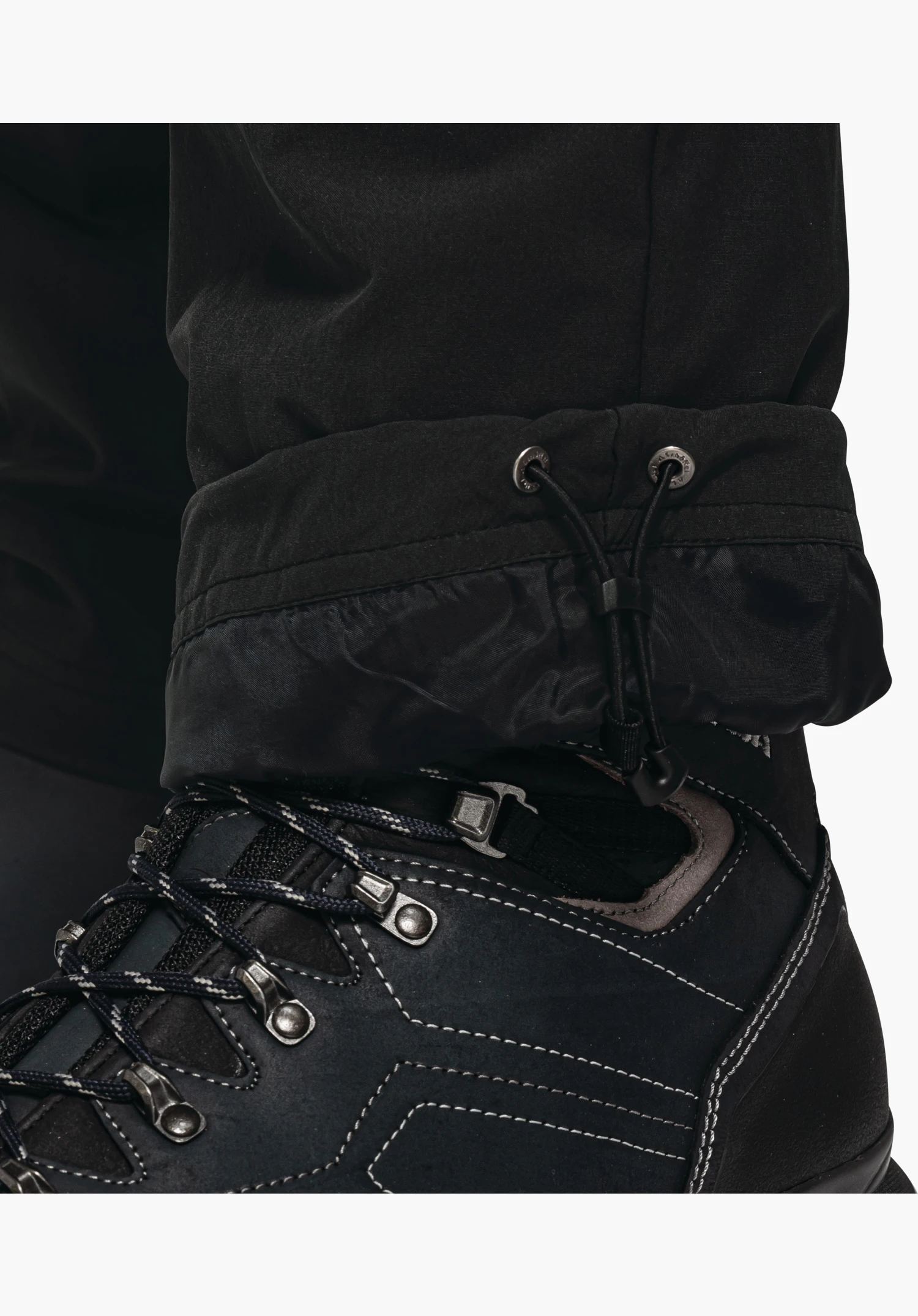 Pants Koper1 Warm M, adjustable leg hem with drawstring and stopper in black, close-up against a white/neutral background.