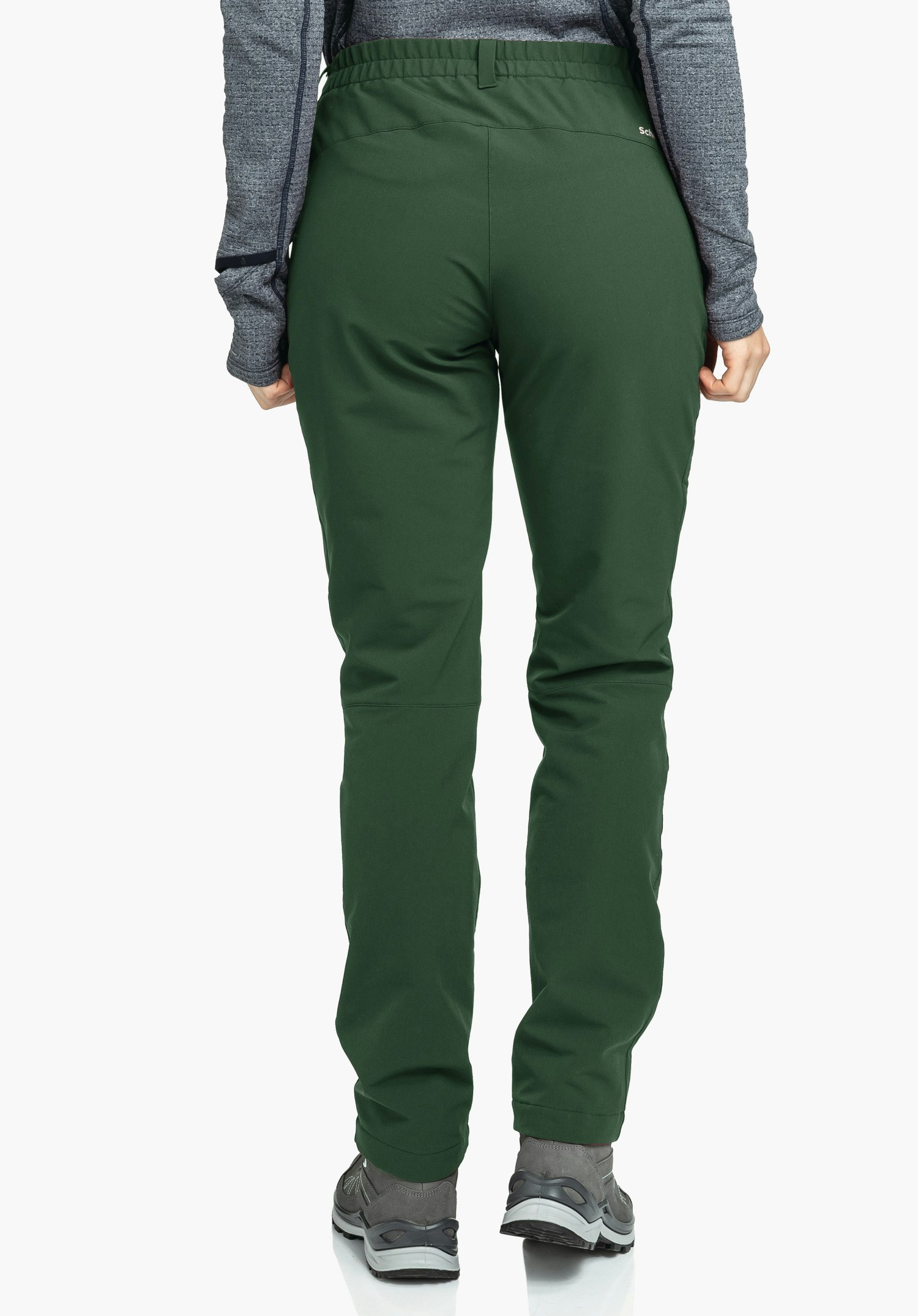 Pants Ascona Warm L pantalon femme vert foncé, porté de dos par une personne debout; contexte: fond blanc, haut gris et chaussures de randonnée grises. Texte: « Schöffel ».