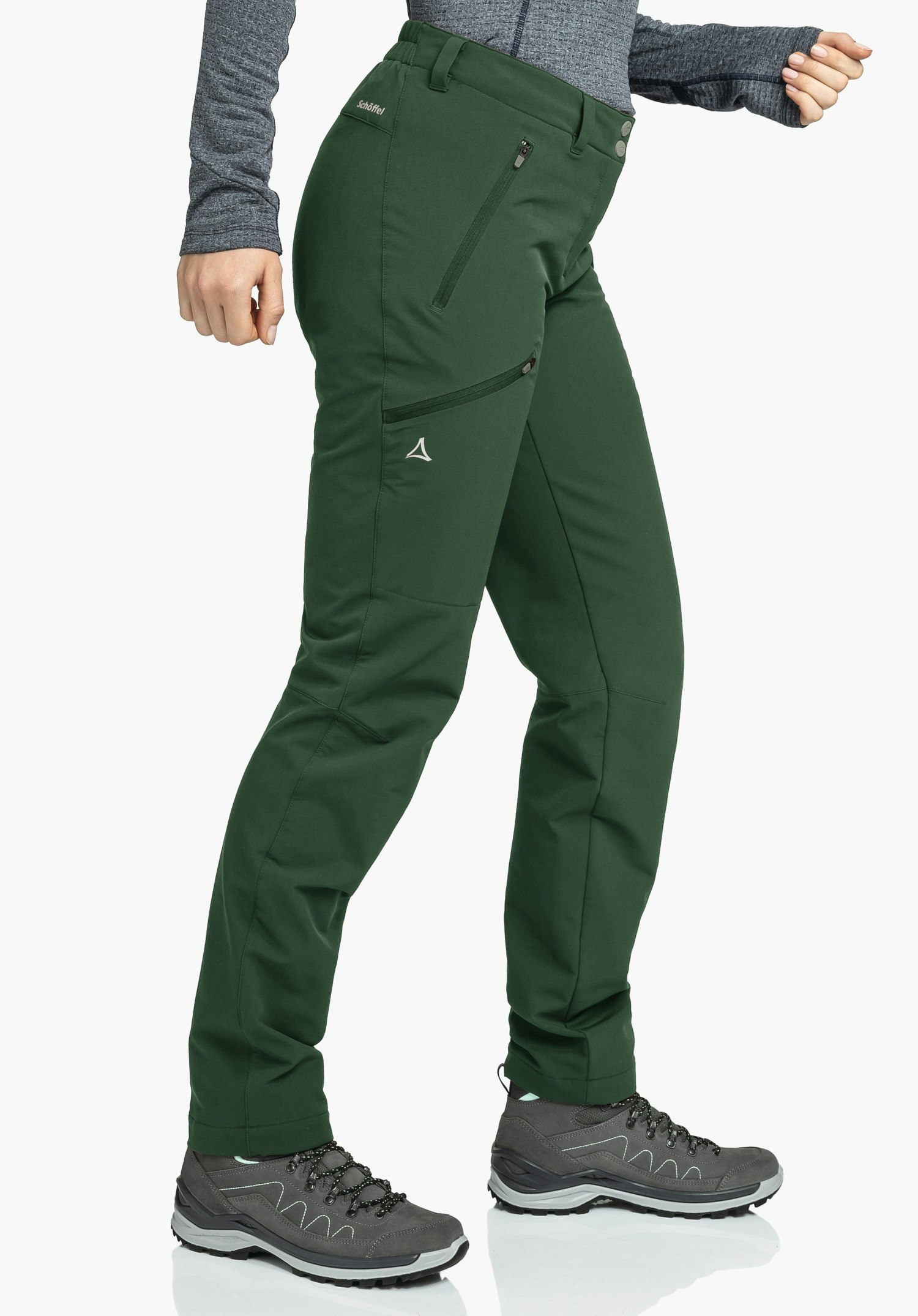Pants Ascona Warm L pantalon outdoor vert foncé porté par une personne debout, avec poches zippées et logo Schöffel (triangle); texte sur le pantalon: "Schöffel"; fond blanc.