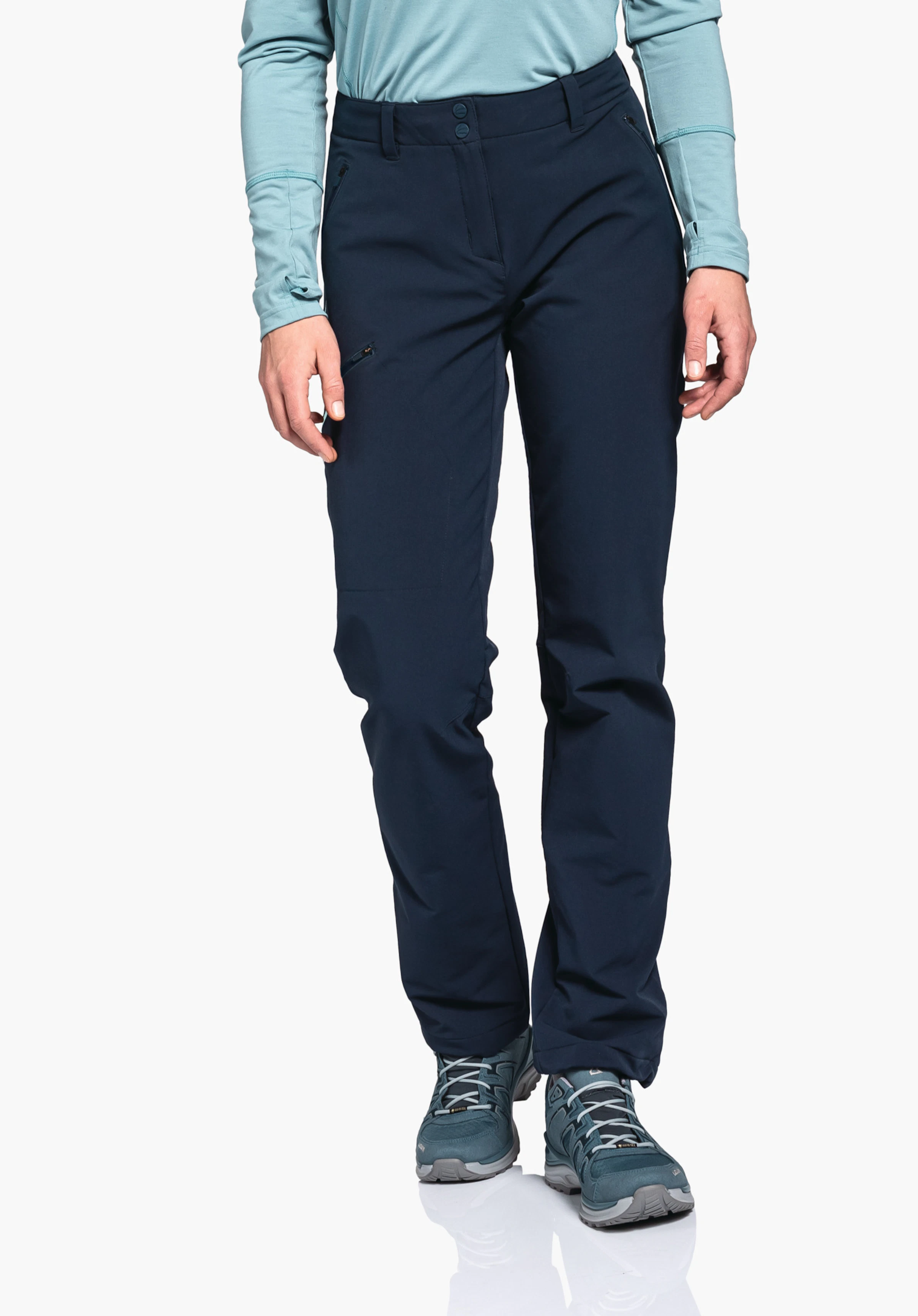 Pants Ascona Warm L Dunkelblaue Outdoorhose; sitzt an stehender Person, Beine leicht gespreizt. Kontext: hellblaues Langarmshirt, dunkelblaue Wanderschuhe, freier weißer Hintergrund, Sicht von Hüfte bis Schuhspitzen.