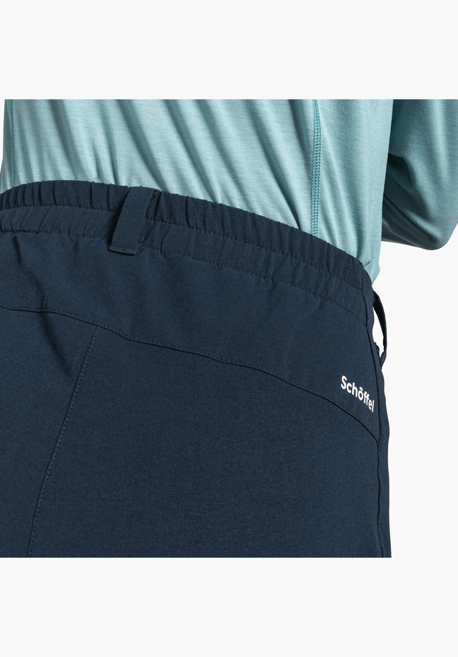 Pants Ascona Warm L mit elastischem Bund, Gürtelschlaufen und dem weißen Schöffel-Logo auf dem blauen Material, Nahaufnahme vor neutralem Hintergrund.