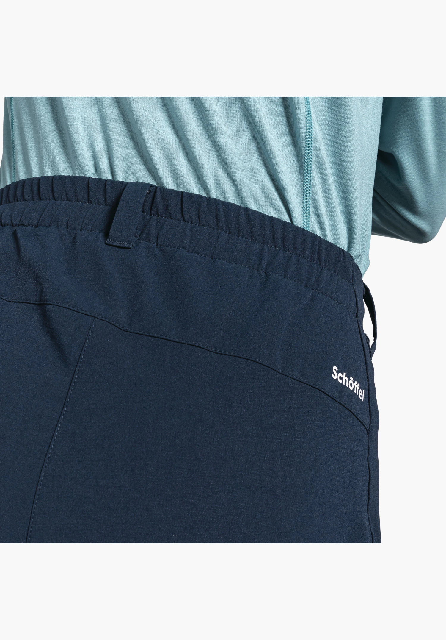 Pants Ascona Warm L mit elastischem Bund, Gürtelschlaufen und dem weißen Schöffel-Logo auf dem blauen Material, Nahaufnahme vor neutralem Hintergrund.