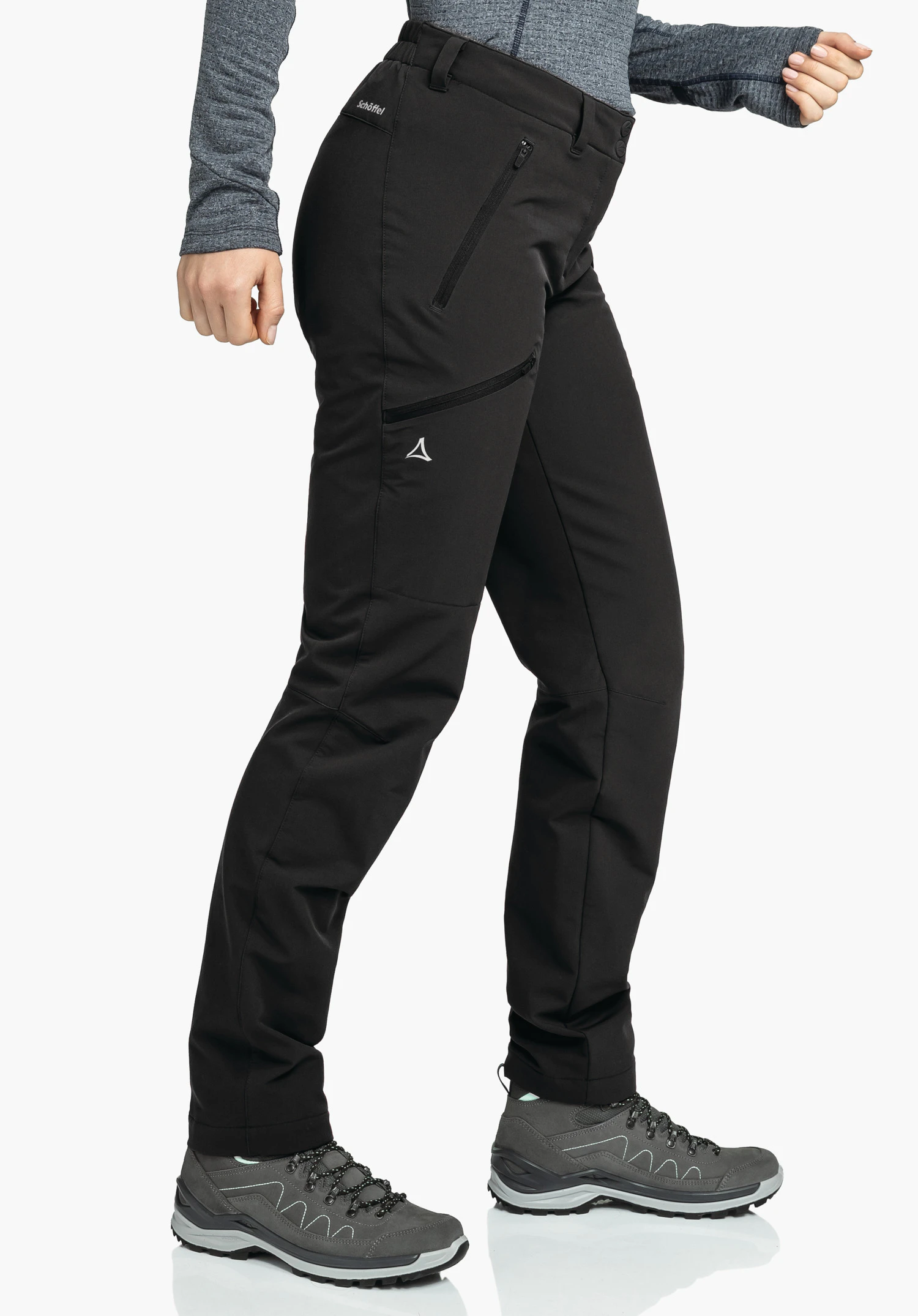 Pants Ascona Warm L schwarze Outdoorhose, seitlich getragen, macht einen Schritt vorwärts; Person mit dunkelgrauem Oberteil und dunkelgrauen Wanderschuhen vor weißem Hintergrund. Text: "Schöffel". Schöffel-Logo sichtbar.