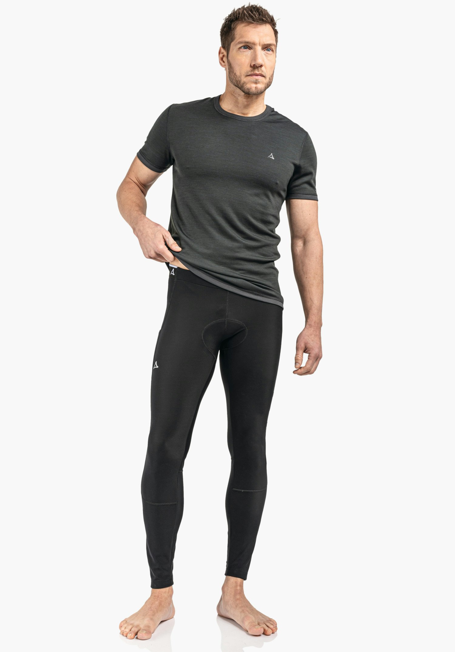 Skin Pants Warm 4h M Detailansicht des elastischen Bundes und des weißen Schöffel-Logos auf dem schwarzen Funktionsmaterial, Nahaufnahme vor weißem/neutralem Hintergrund.