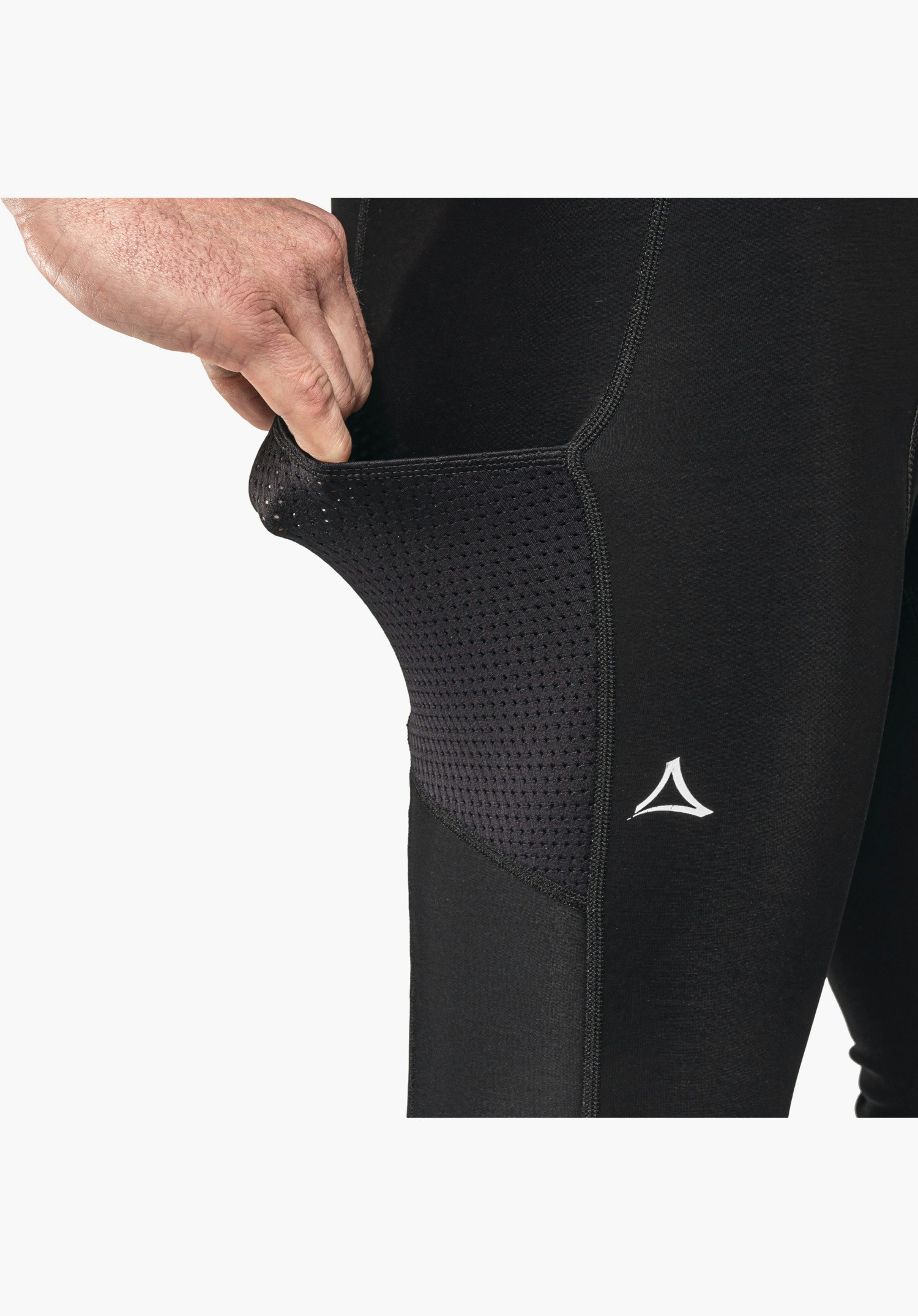 Skin Pants Warm 4h M, seitliche Netztasche am Oberschenkel in Schwarz, die von einer Hand leicht geöffnet wird, sowie das weiße Schöffel-Logo. Nahaufnahme vor weißem Hintergrund.