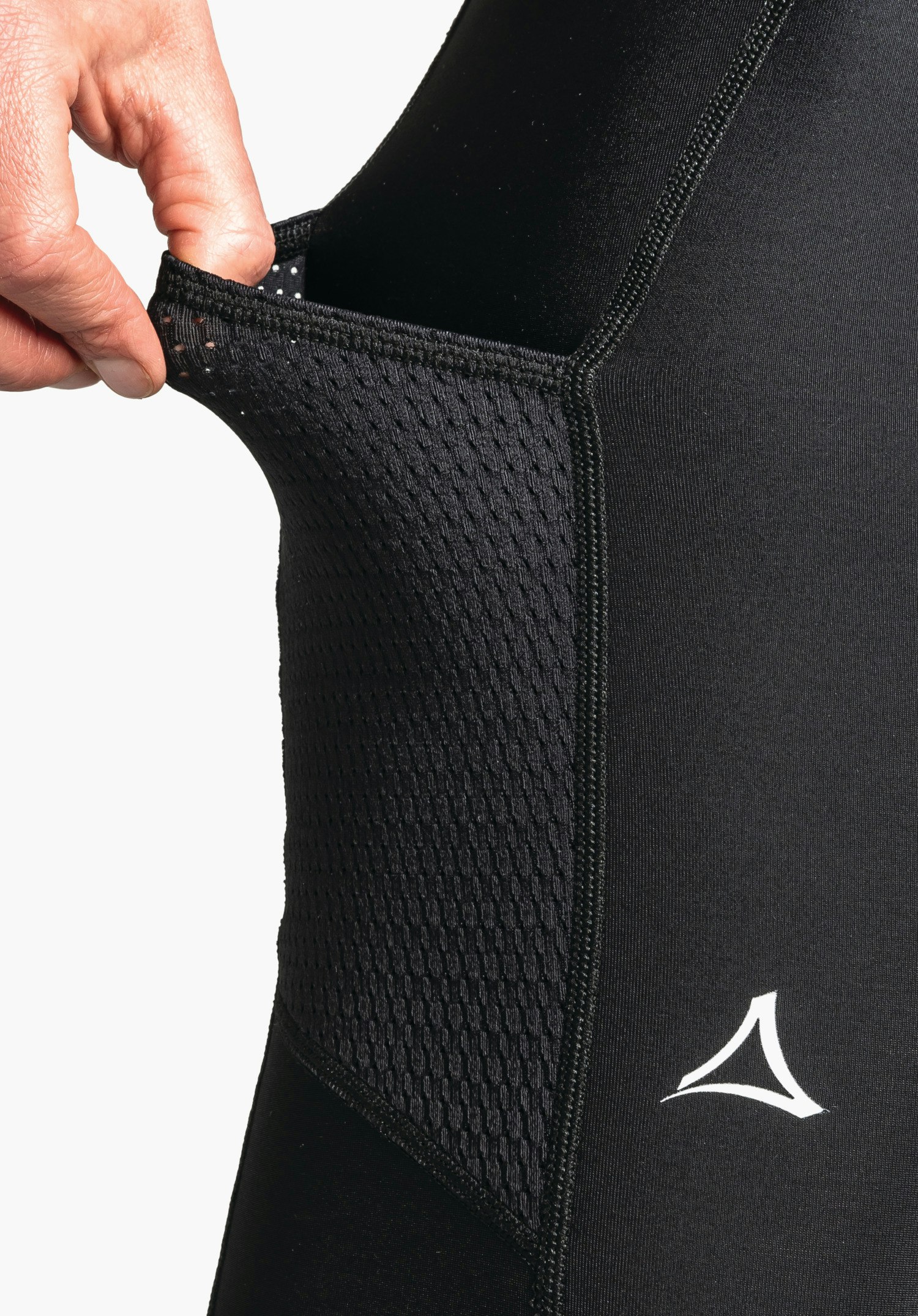 Skin Pants Warm 4h L avec une poche en maille élastique sur la cuisse en noir et le logo Schöffel blanc en gros plan sur fond blanc/neutre.