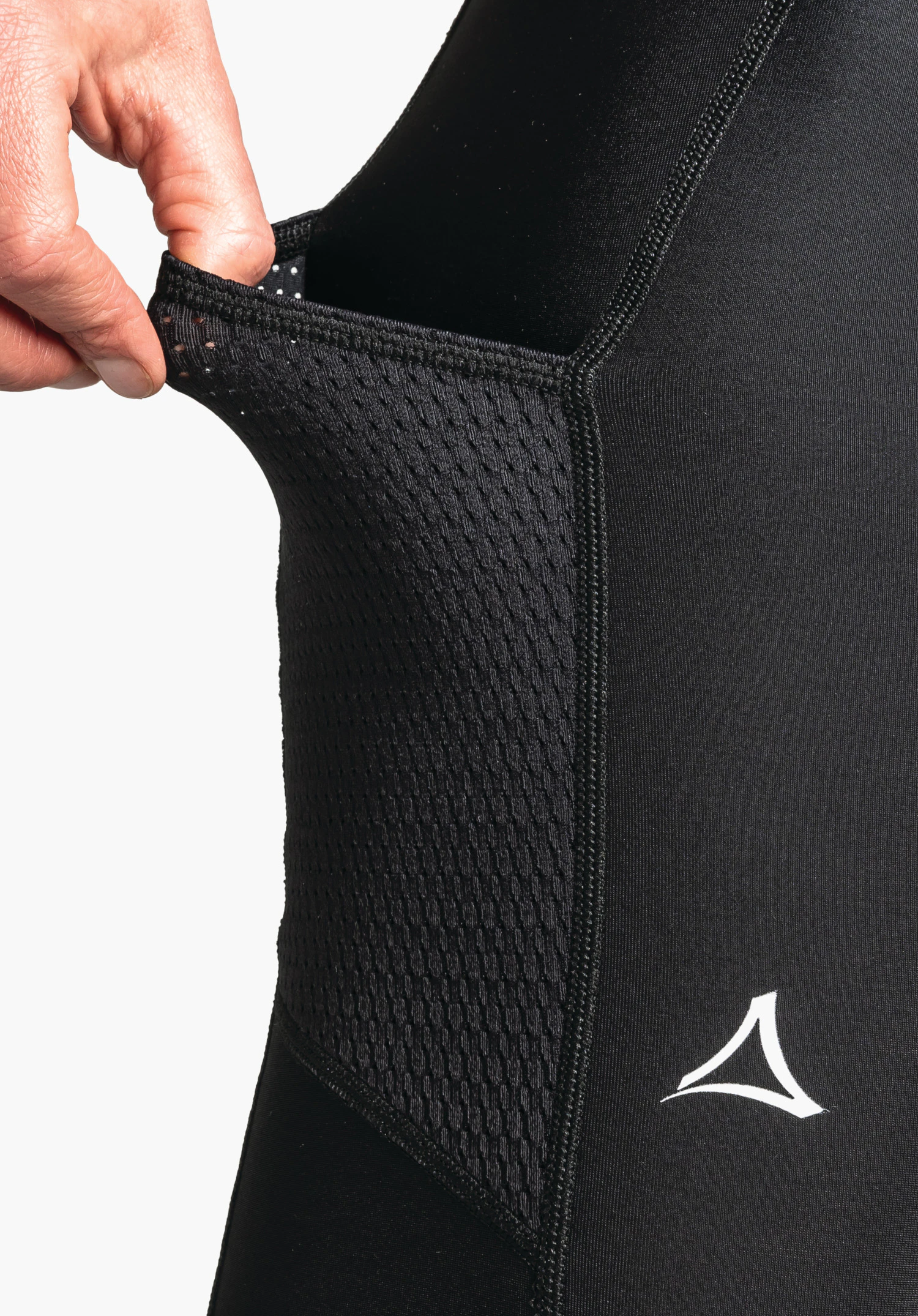 Skin Pants Warm 4h L avec une poche en maille élastique sur la cuisse en noir et le logo Schöffel blanc en gros plan sur fond blanc/neutre.