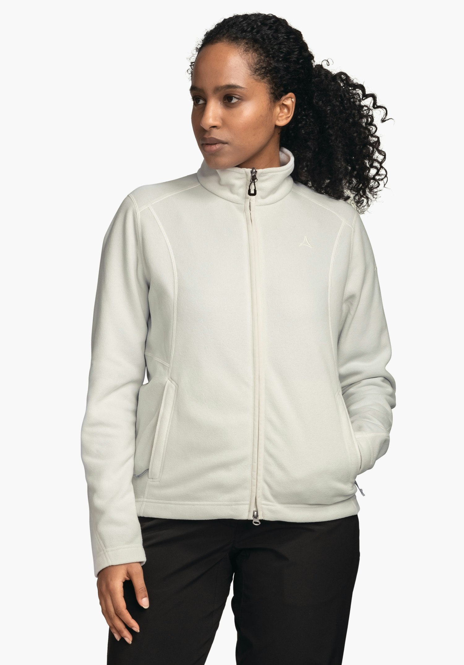 Fleece Jacket Leona3 off-white fleece jacket with zip, worn by a woman standing sideways; hands in pockets, white background; Schöffel logo on the chest.