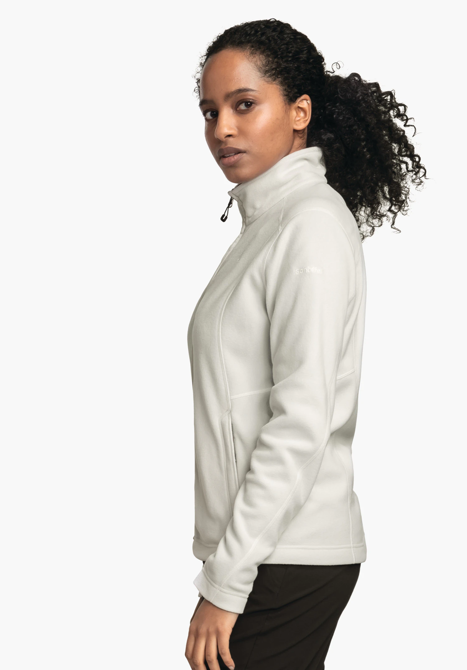 Fleece Jacket Leona3 jacket; woman wears a light white fleece jacket with stand-up collar, stands side-on and looks towards the camera in front of a plain white background. Text: "schöffel".