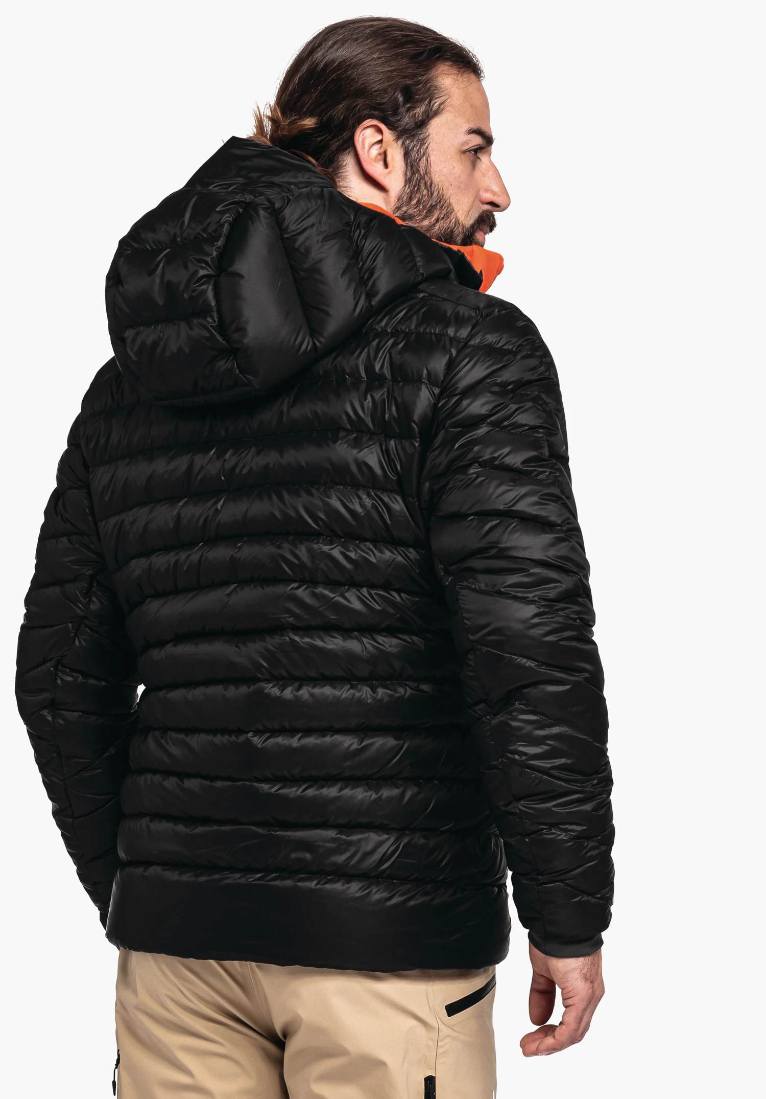 Down Jacket Silvretta M deep black quilted jacket worn by a man turning to the right; visible hood and quilted pattern; white studio background.