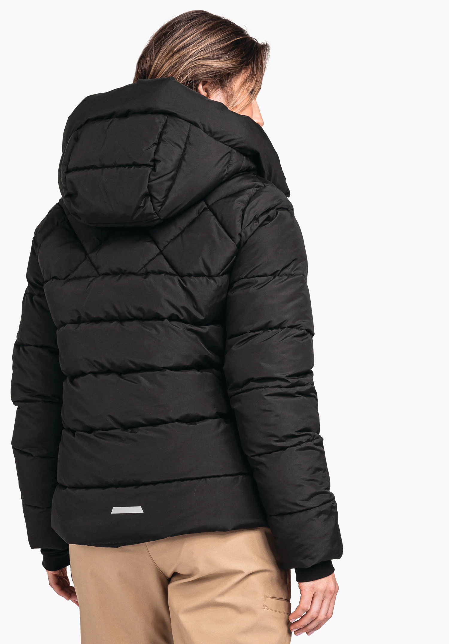 Ins Jacket Boston L black quilted jacket with large hood worn by a person standing with back to the camera and looking sideways; white background.