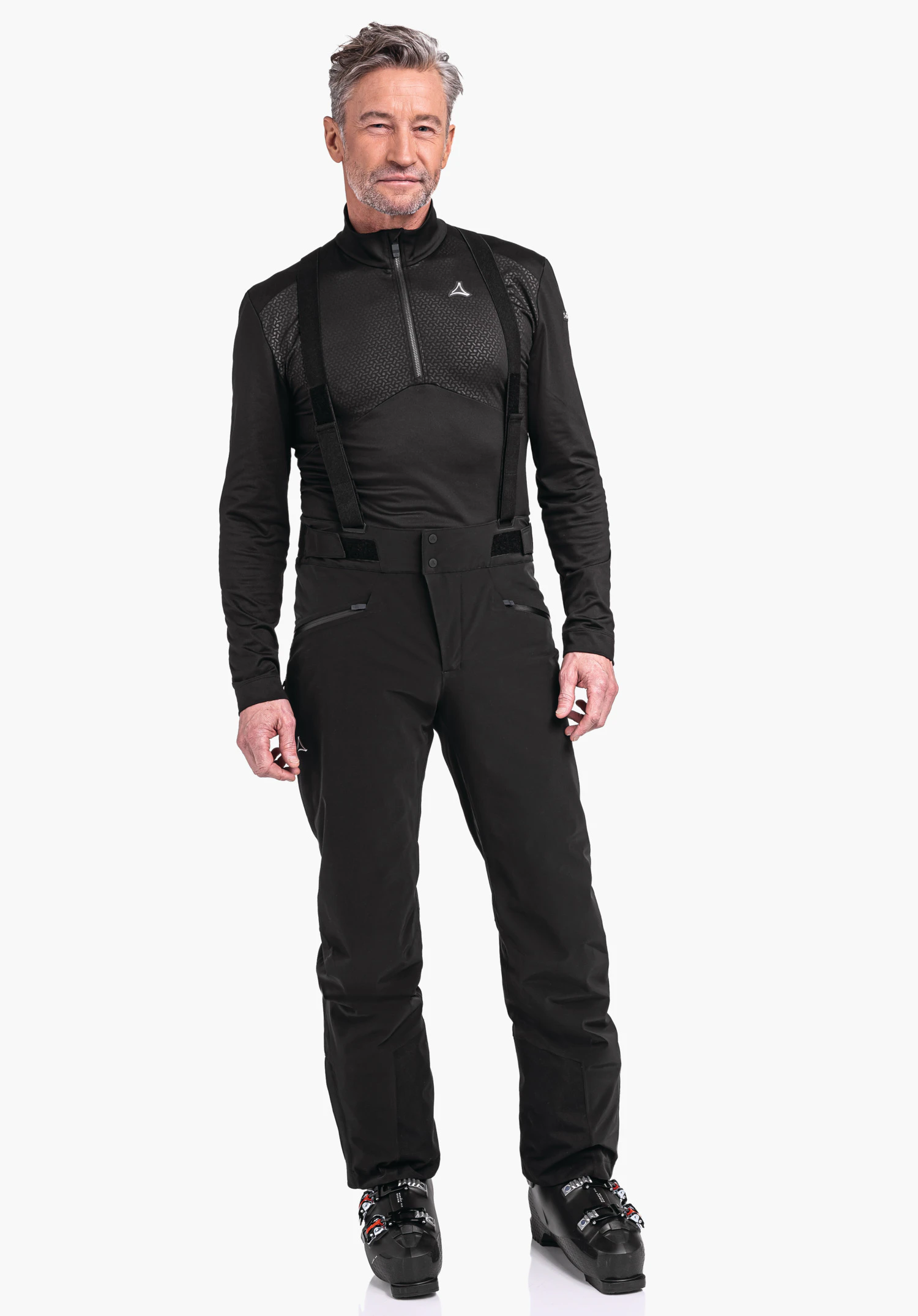 Ski Pants Trevalli M man in a black ski top and black ski trousers with braces stands front-facing with arms relaxed at the sides; Schöffel logo on the chest; white studio background.
