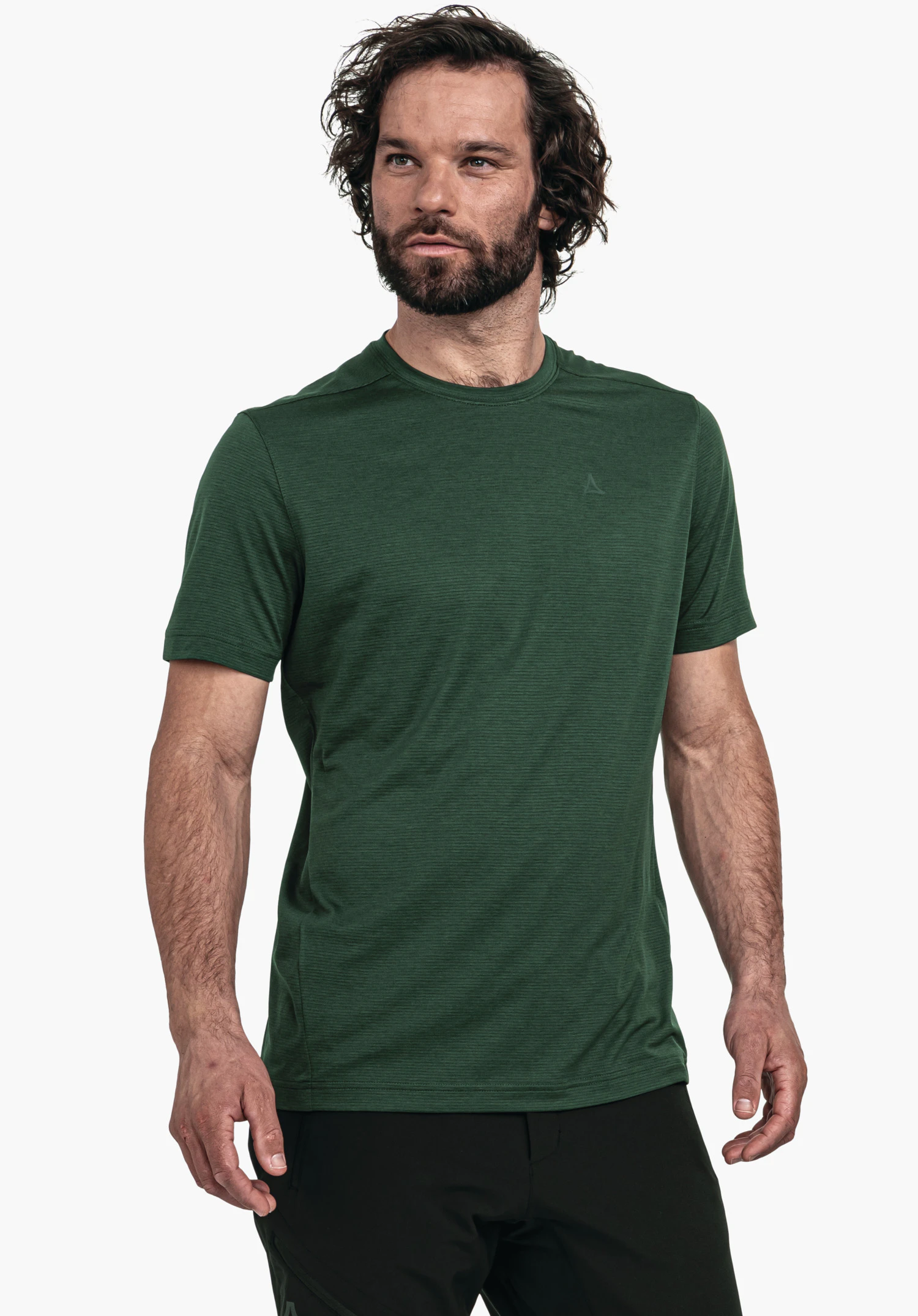 CIRC T Shirt Tauron M T-shirt vert foncé avec logo Schöffel; porté par un homme légèrement de côté regardant vers la droite; manches courtes, barbe, cheveux bouclés; fond blanc lumineux.