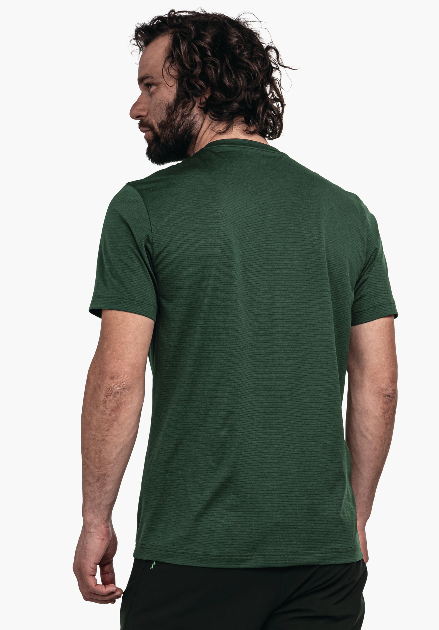 CIRC T Shirt Tauron M T-shirt homme vert foncé, porté de dos par un homme; manches courtes, dos lisse; homme aux cheveux foncés bouclés et à la barbe; fond studio clair neutre.