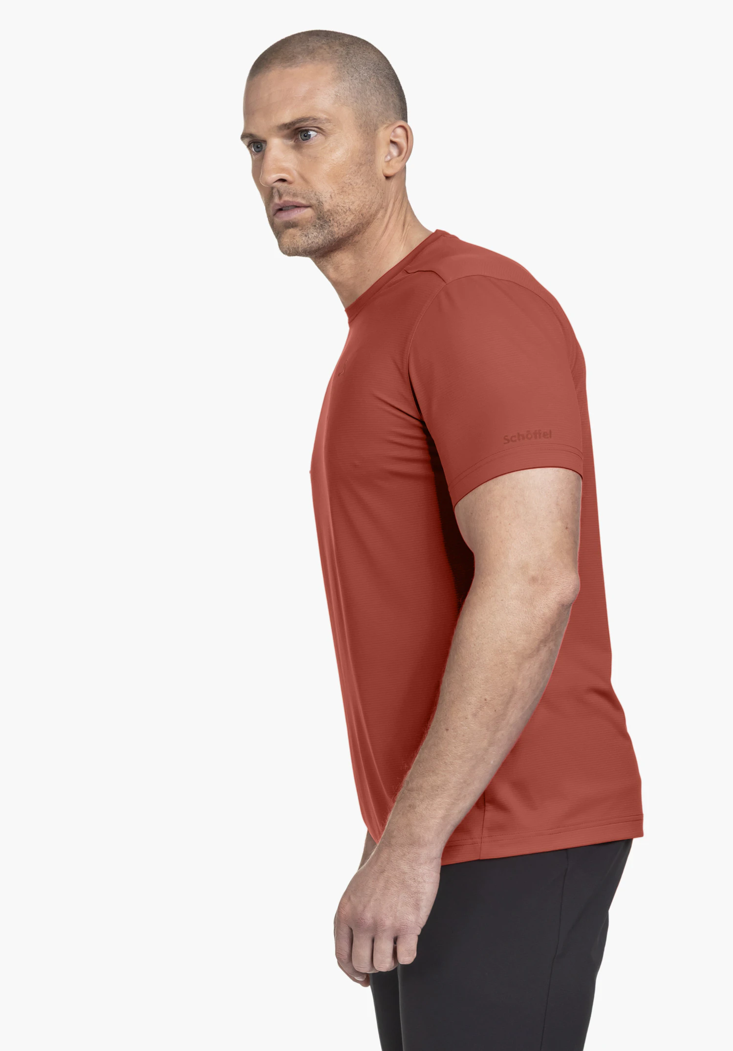 CIRC T Shirt Tauron M in red. The model is shown from a side profile against a neutral background, highlighting the shirt with the subtle Schöffel logo on the sleeve.