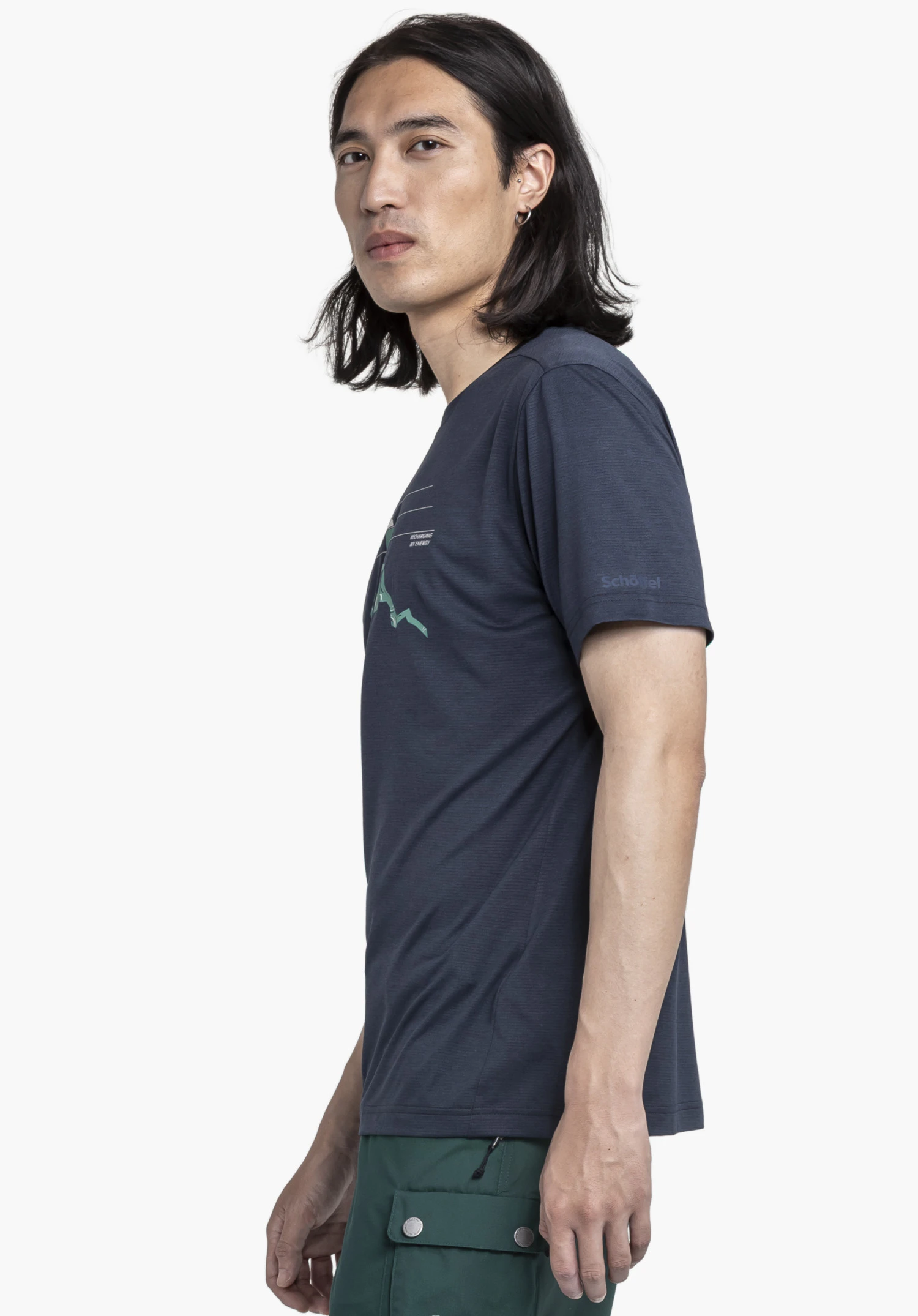 CIRC T Shirt Sulten M. Der männliche Träger steht seitlich vor einem neutralen Hintergrund und präsentiert das blaue Shirt. Der Blick ist direkt in die Kamera gerichtet, während das dezente Schöffel-Logo auf dem Ärmel deutlich zu erkennen ist.