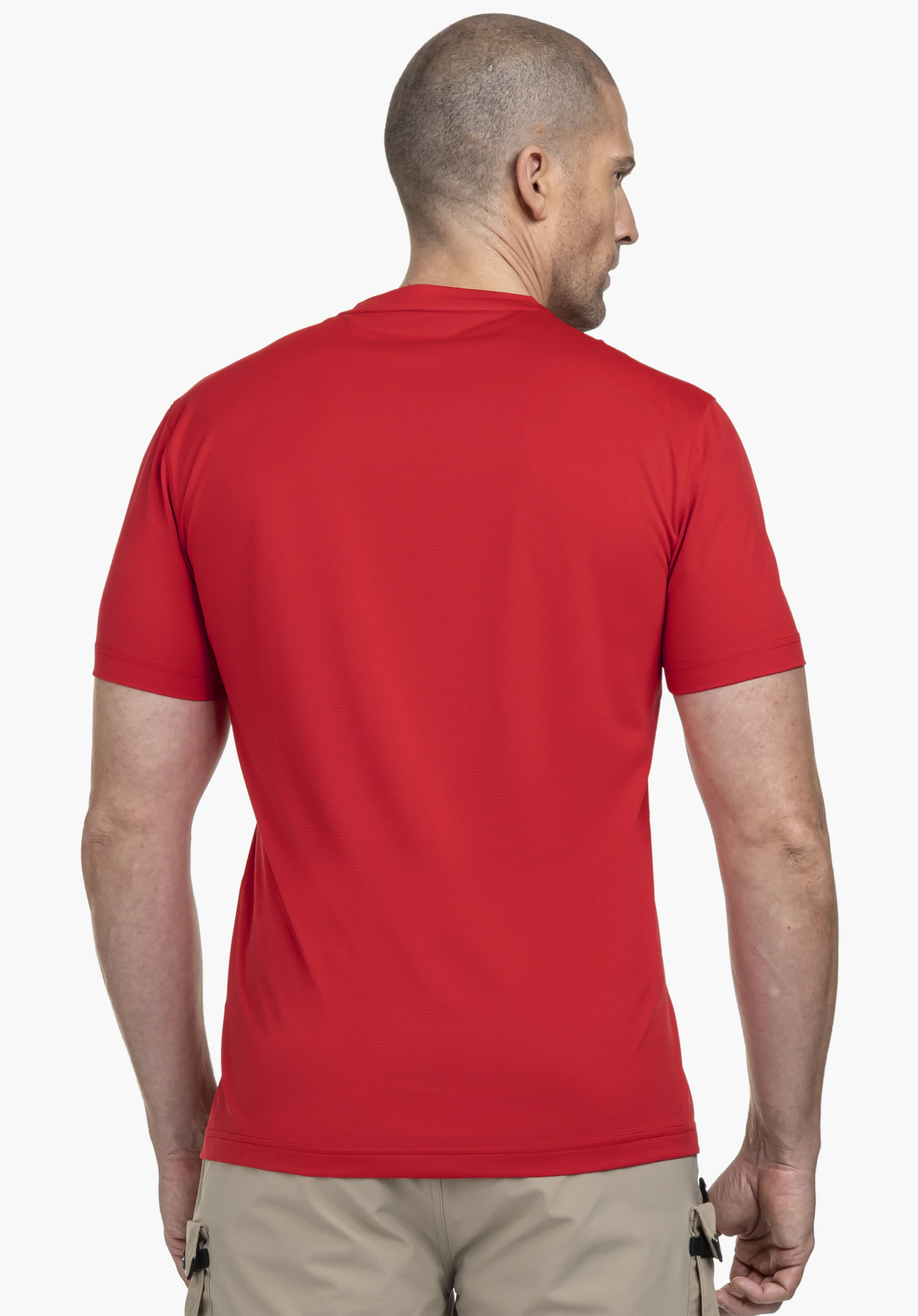 CIRC T Shirt Sulten M : Un homme est vu de dos, portant le t-shirt dans un rouge éclatant. Le modèle se tient devant un fond neutre et porte le t-shirt de manière décontractée avec un short beige, mettant en valeur la coupe épurée idéale pour les journées d'hiver actives.