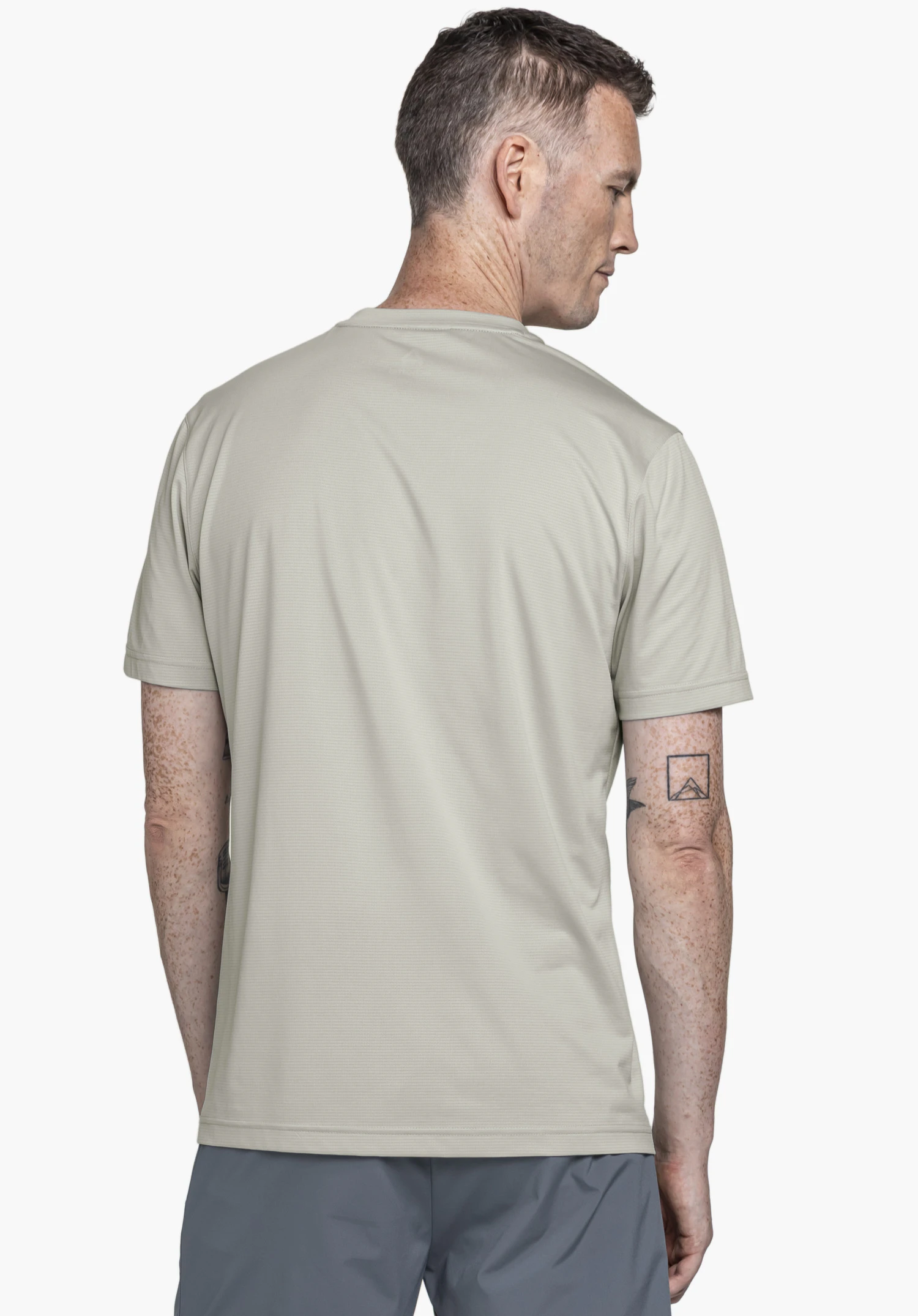 CIRC T Shirt Sulten M in Grau: Das Model zeigt das T-Shirt in einer Rückenansicht vor neutralem Hintergrund und blickt leicht über die Schulter zur Seite.