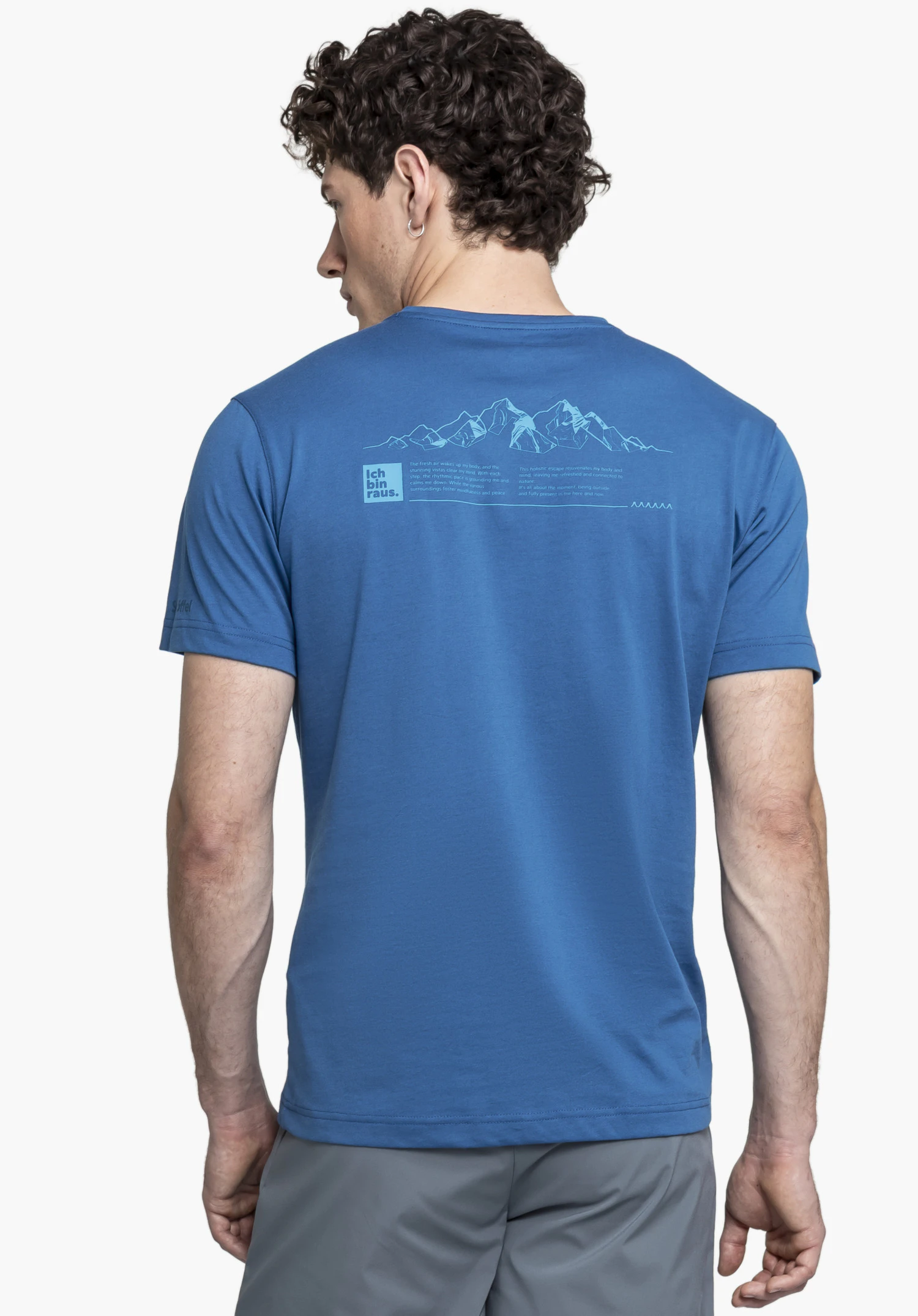 T Shirt Buchberg M en bleu présenté de dos sur un fond neutre. Le mannequin porte le t-shirt avec un imprimé montagne distinctif et l'inscription « Ich bin raus » dans le dos, tandis que le logo Schöffel est visible discrètement sur la manche.