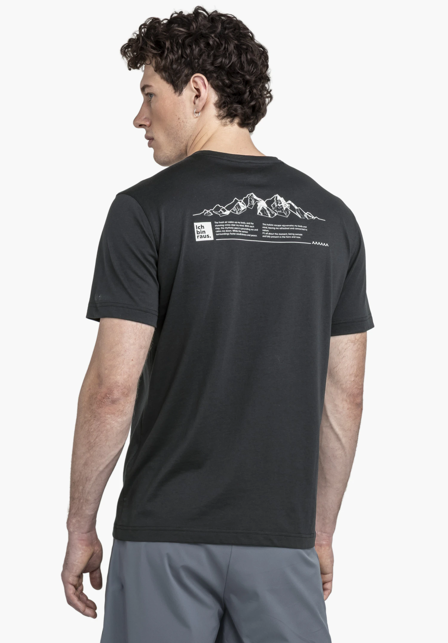 T Shirt Buchberg M in classic black. The image shows a male athlete from behind against a neutral background. The focus is on the graphic back print featuring a mountain motif and the subtle Schöffel logo.