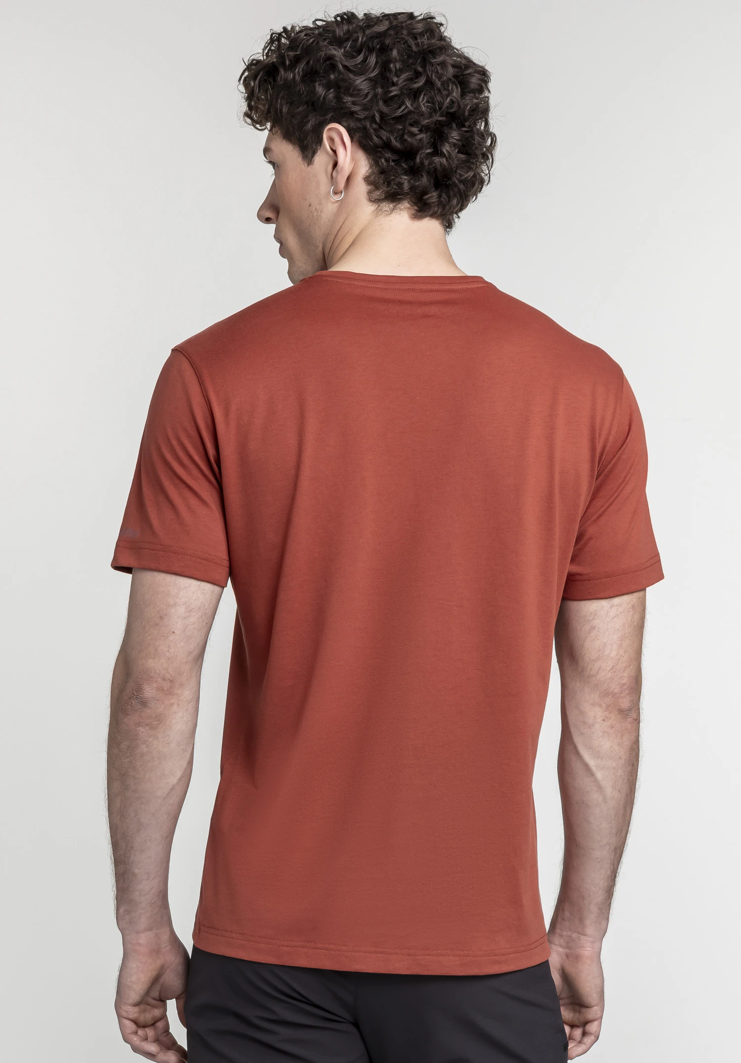 T Shirt Hohberg M in vibrant red shown from the back. The model is standing in front of a neutral background, highlighting the clean design of the shirt with the subtle Schöffel logo placed on the sleeve hem.