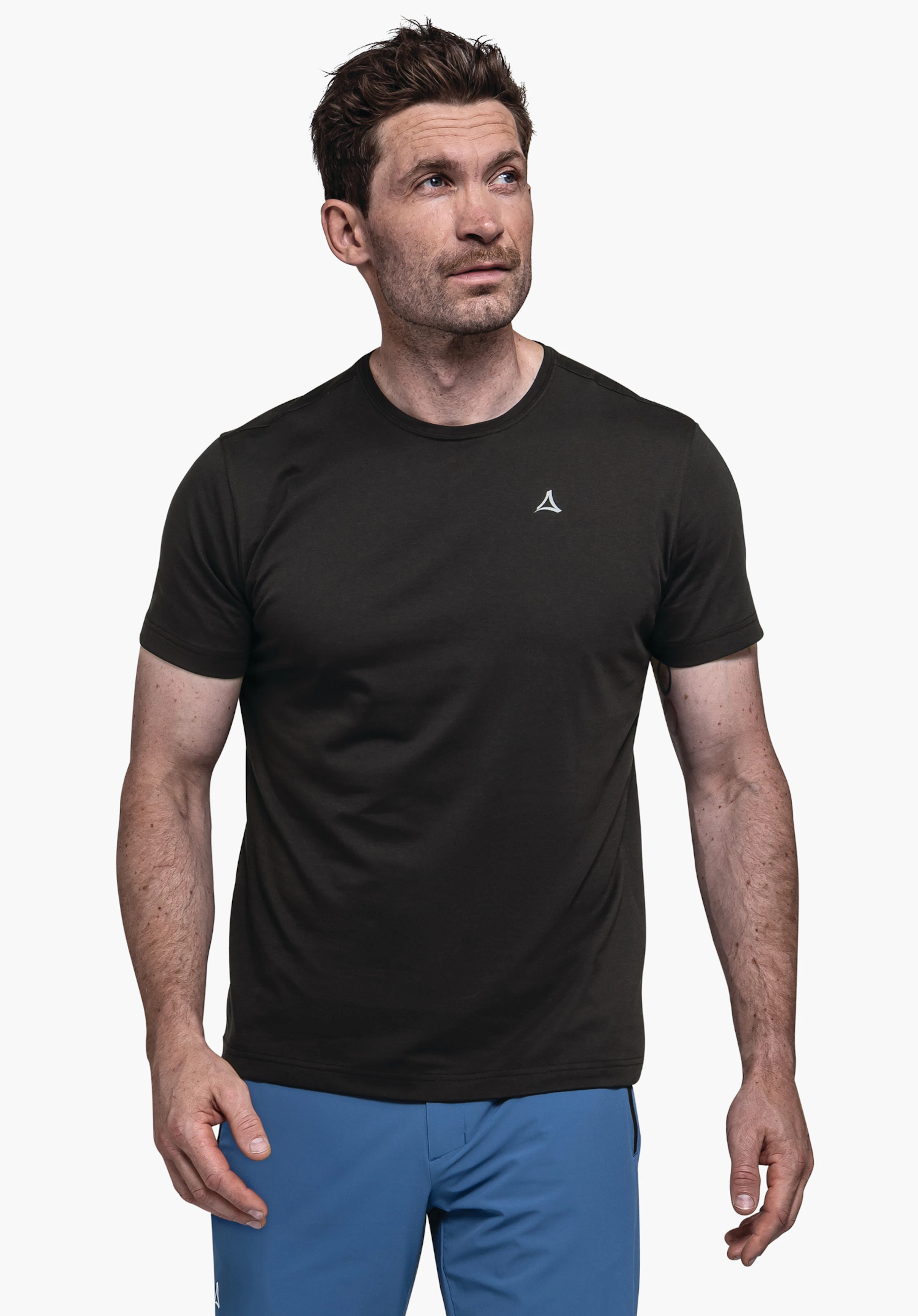 T Shirt Hohberg M in het zwart. Het model staat frontaal voor een neutrale achtergrond en presenteert het T-shirt. Het subtiel op de borst geplaatste Schöffel-logo maakt het sportieve ontwerp compleet.