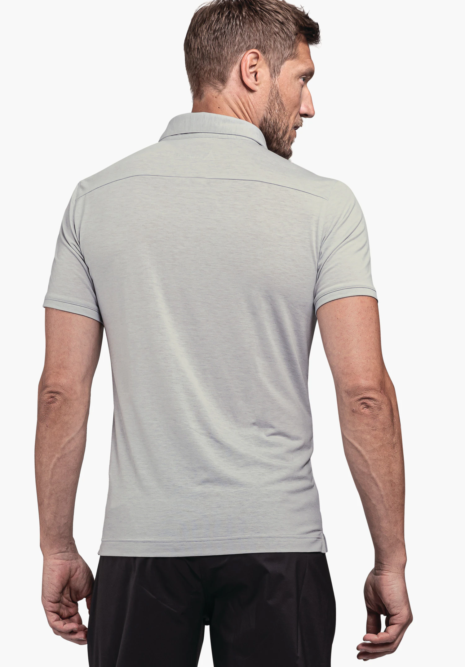 Polo Shirt Ramseck M in grey. The model is shown from the back, looking slightly over the shoulder against a neutral background. The Schöffel logo is subtly placed in the neck area.