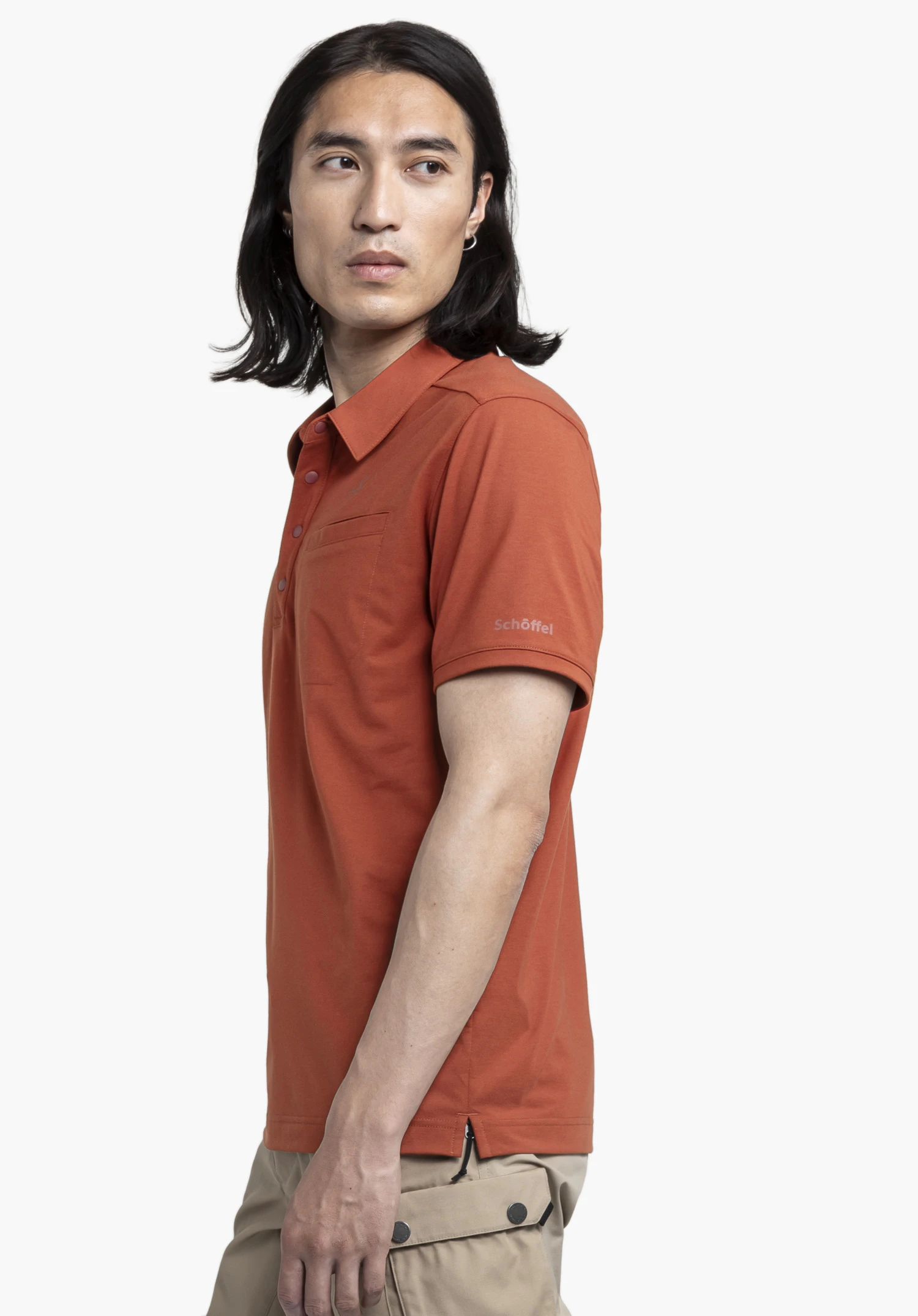 Polo Shirt Ramseck M en rouge : Le mannequin est présenté de profil sur un fond neutre, portant le polo avec le logo Schöffel bien visible sur la manche.