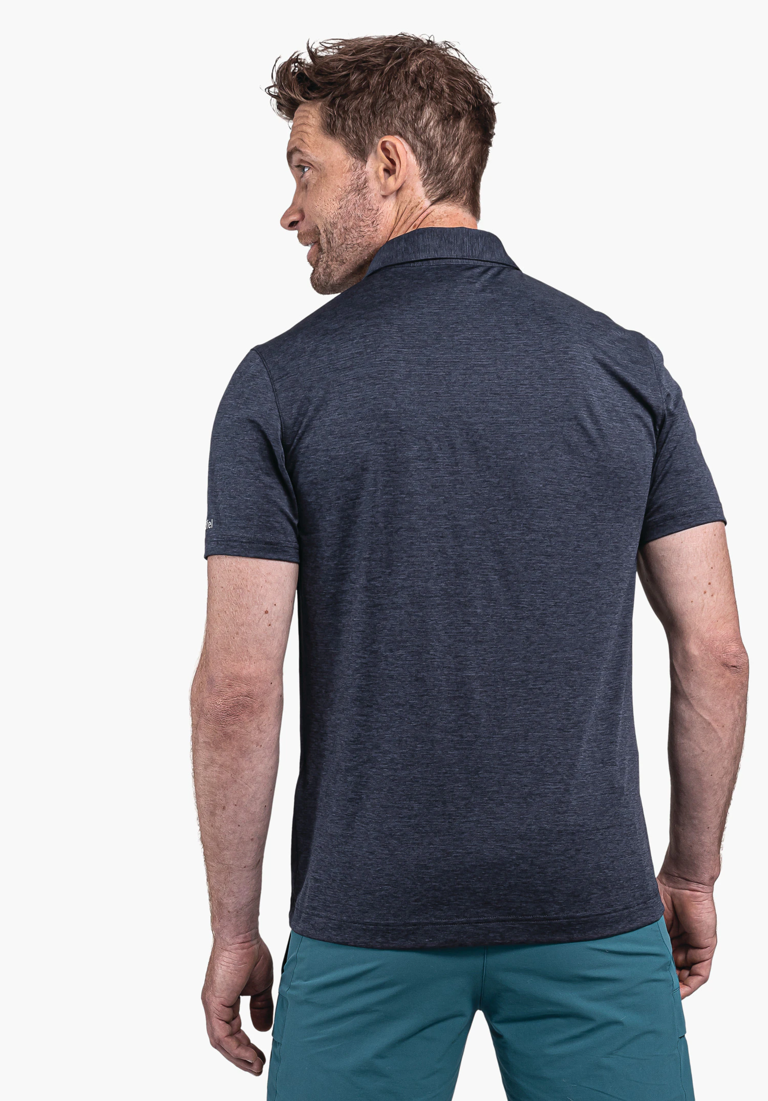 CIRC Polo Shirt Tauron M: The model wears the polo shirt in blue, shown from a rear perspective. He looks slightly to the side, highlighting the subtly placed Schöffel logo on the sleeve. The garment is captured against a neutral background.