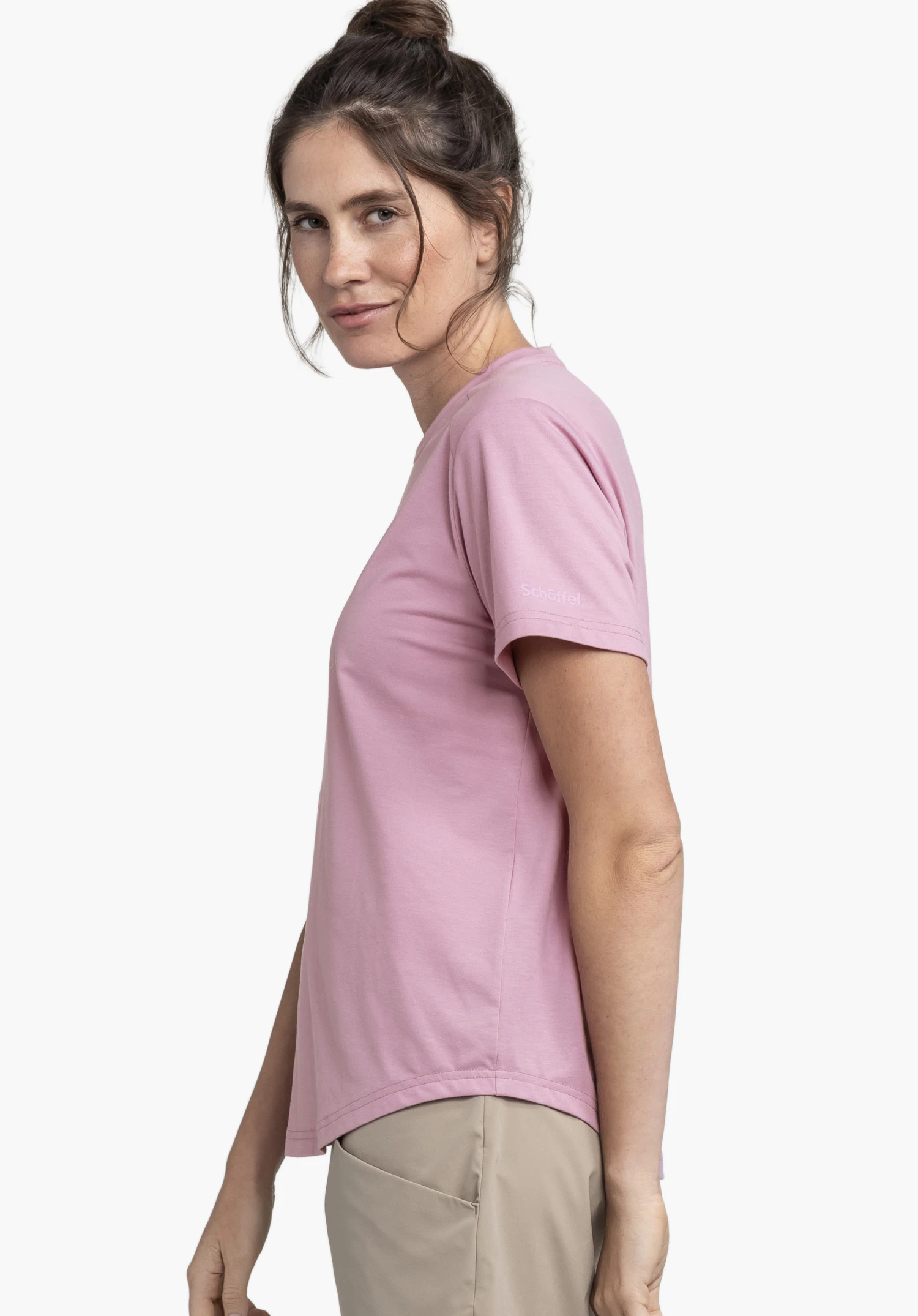 T Shirt Haberspitz L en rose porté par un mannequin de profil. Le mannequin se tient latéralement devant un fond neutre, le logo Schöffel discret sur la manche est bien visible.