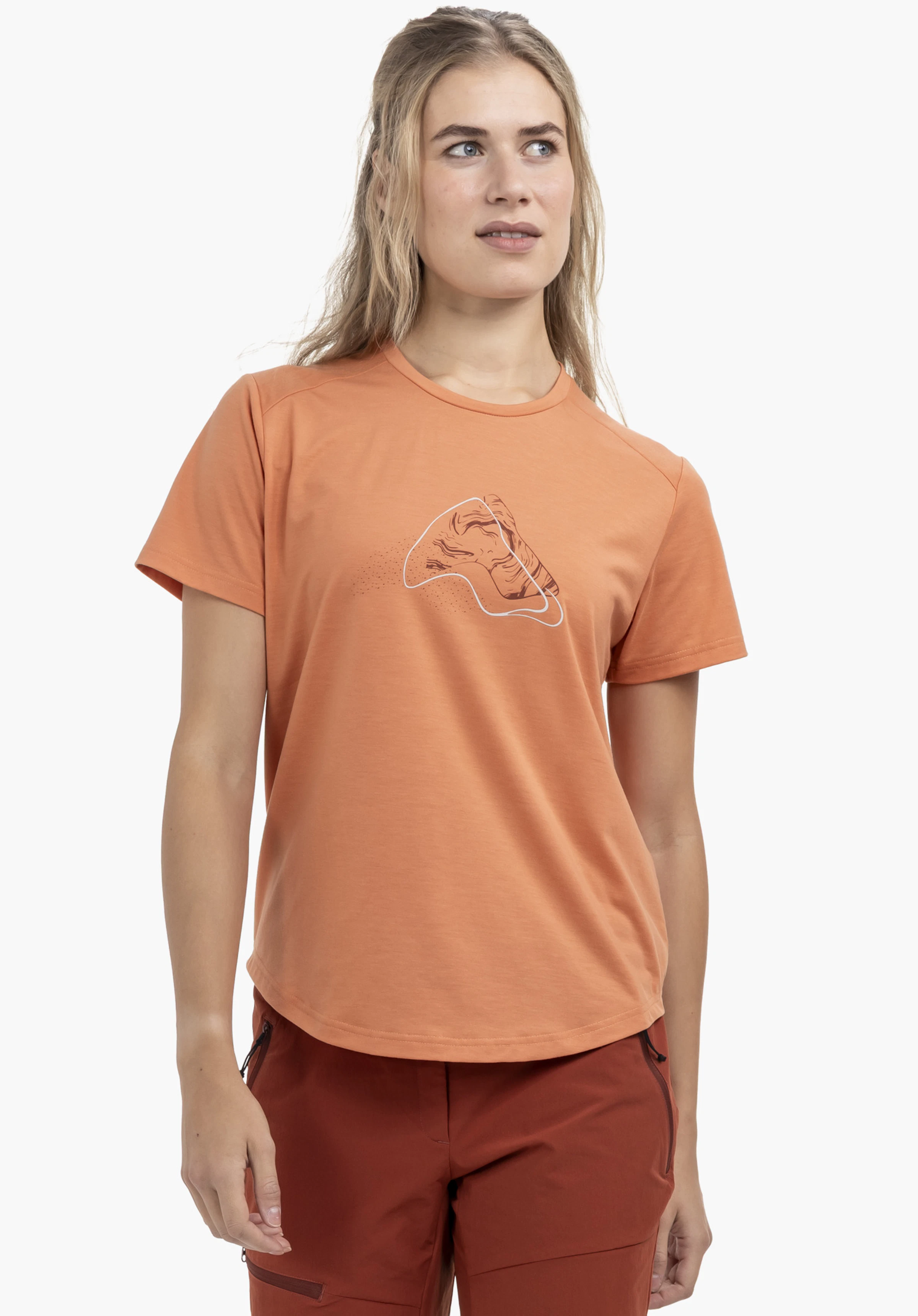 T Shirt Haberspitz L on a female model in the colour orange. The woman is standing frontally, showcasing the short-sleeved shirt with a mountain graphic on the chest in front of a neutral background.