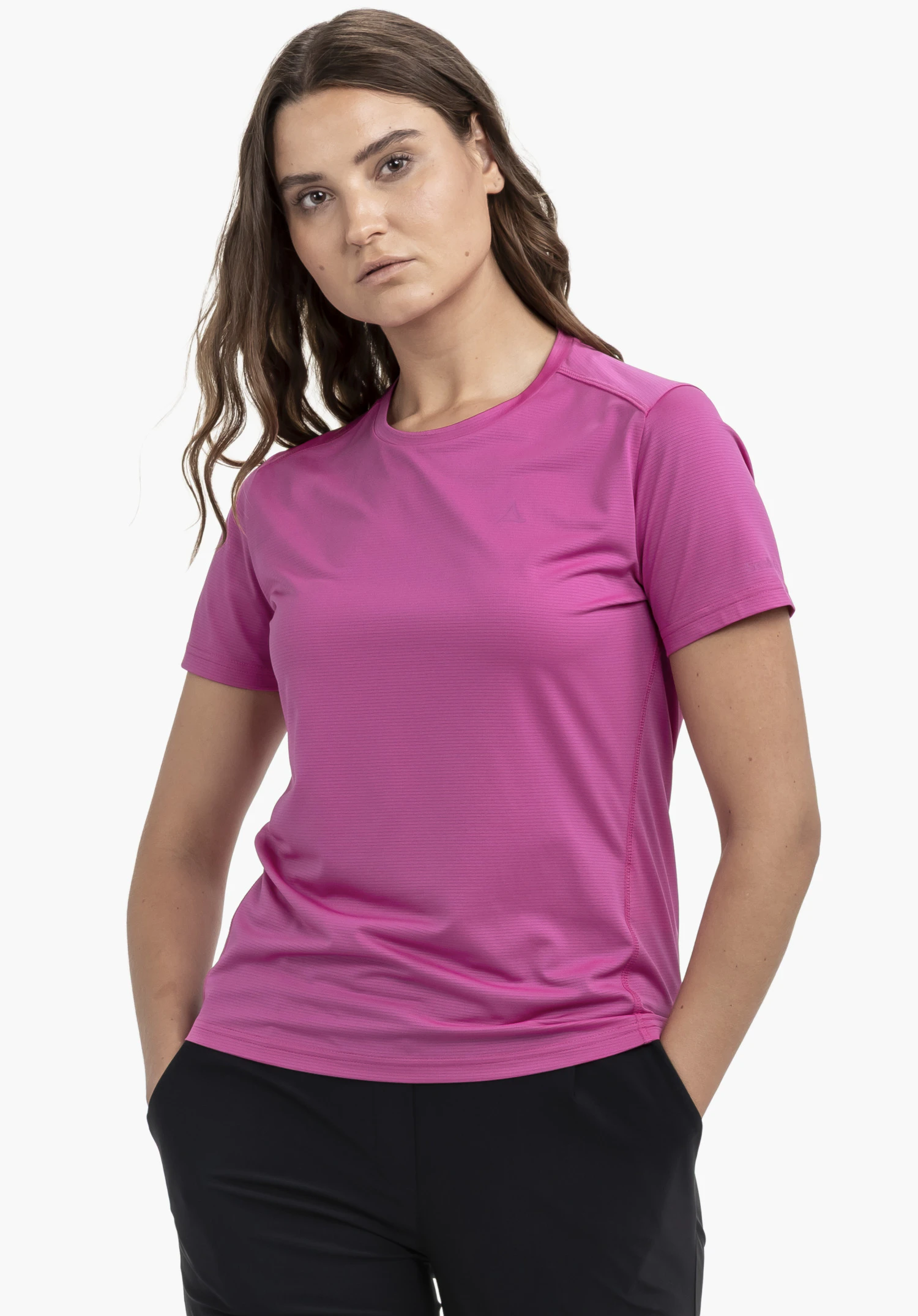 CIRC T Shirt Tauron L en pink. Le mannequin se tient de face, les mains dans les poches, et porte le t-shirt avec un logo Schöffel discret sur la poitrine gauche, photographié devant un fond neutre.