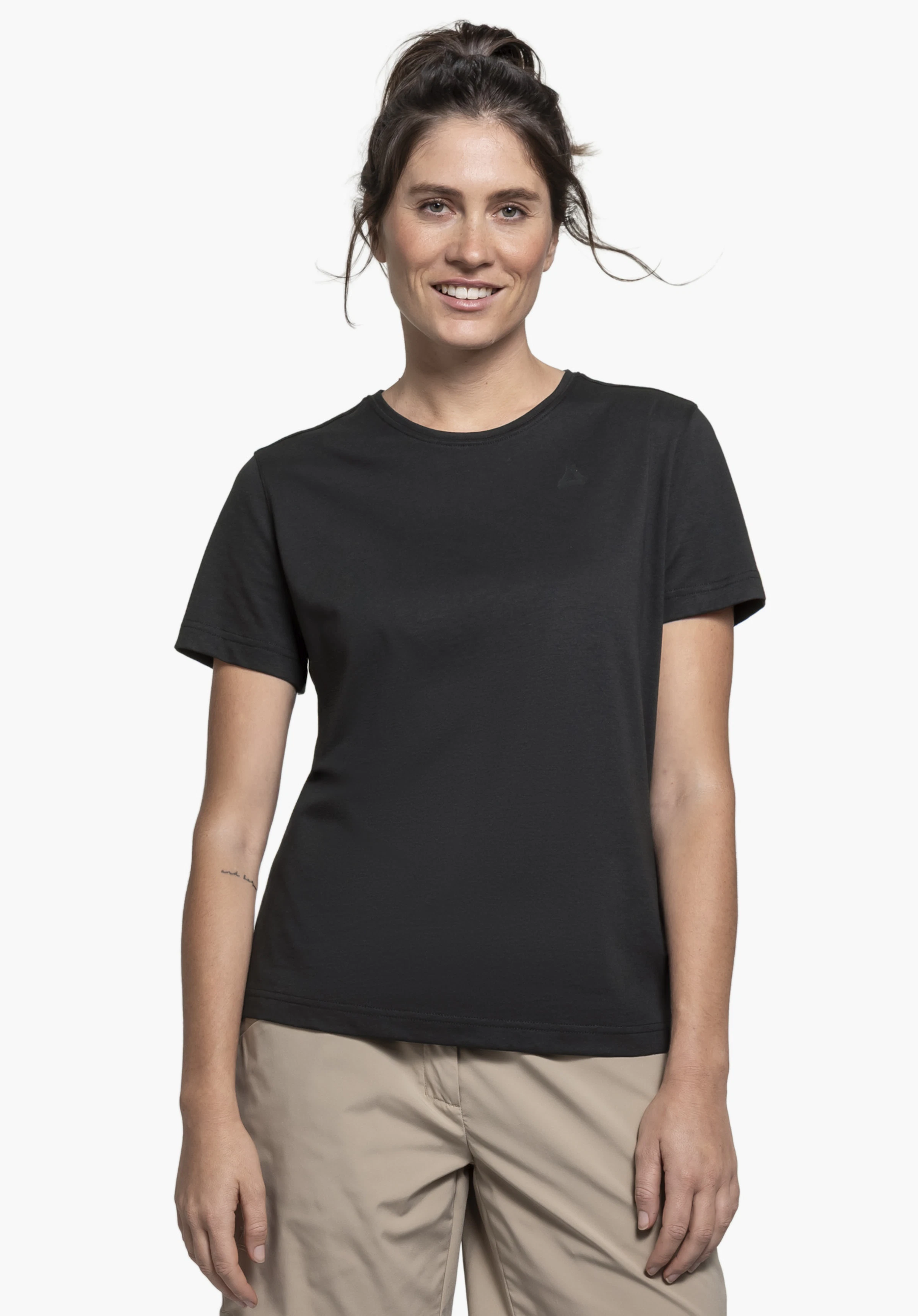 T Shirt Buchberg L: A model stands facing the camera, presenting the black shirt with a visible Schöffel logo on the left chest against a neutral background.