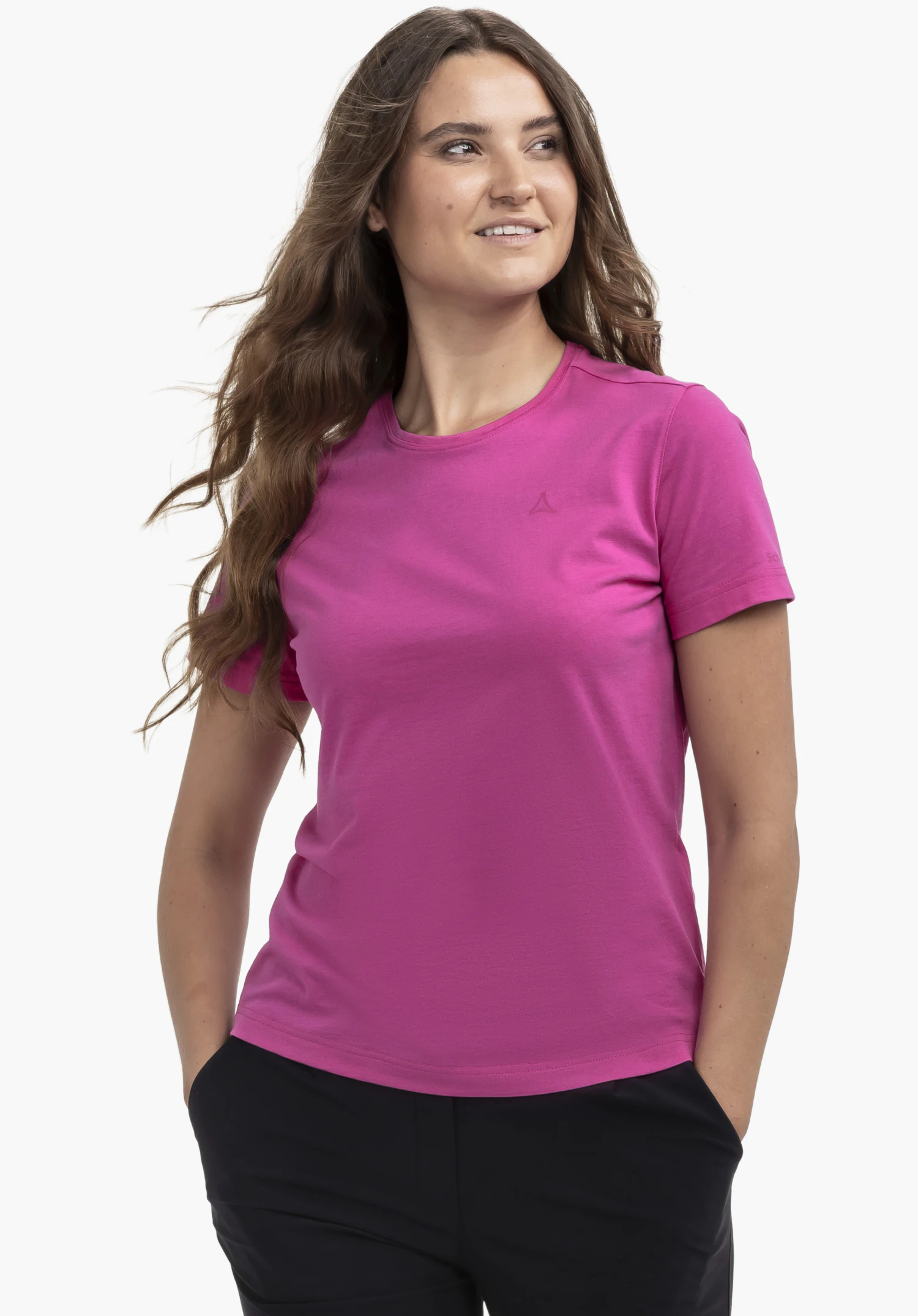 T Shirt Hohberg L is worn by a model standing facing forward with her hands in her pockets. The pink shirt features the Schöffel logo on the left chest and is presented against a neutral background.