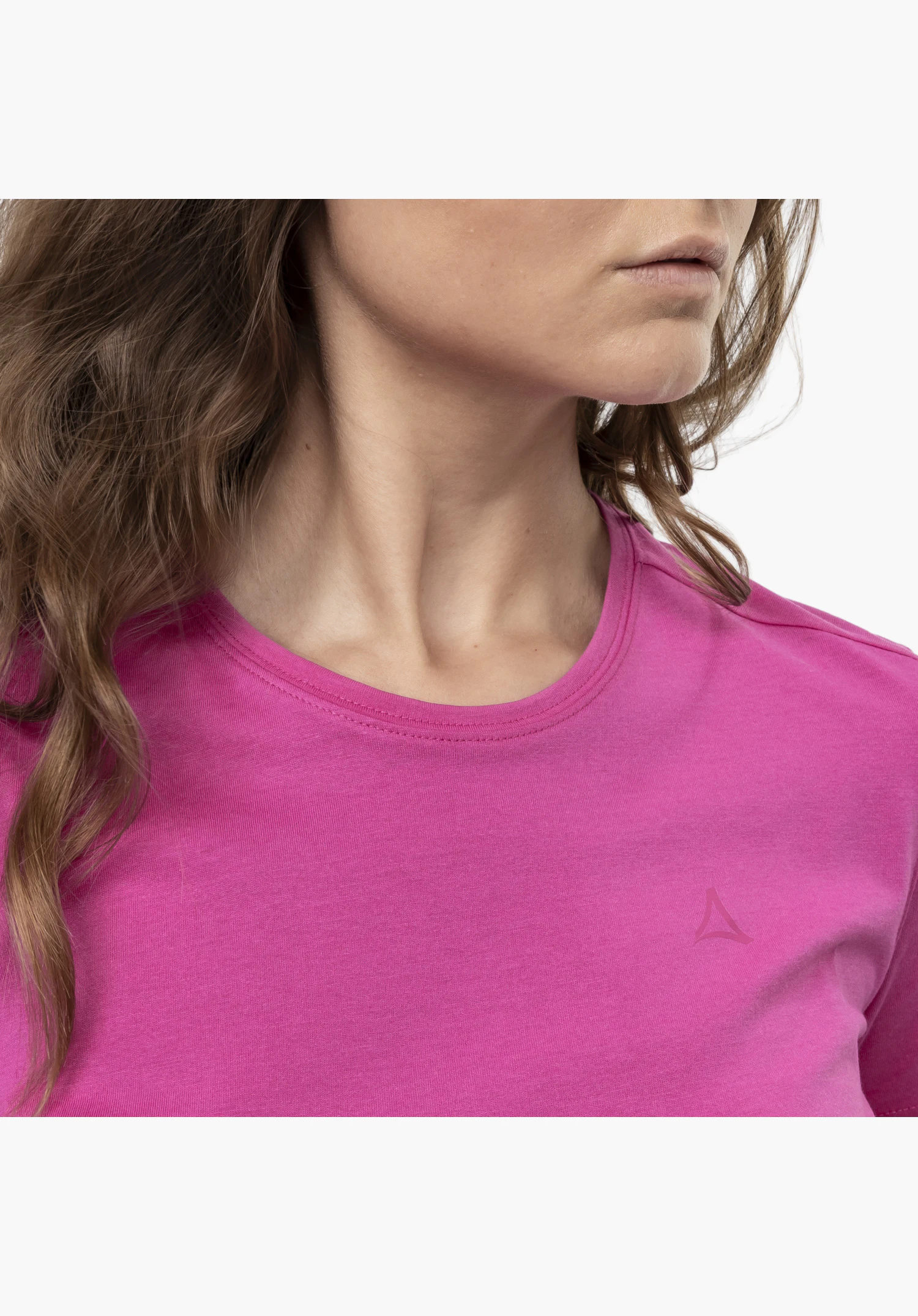 T Shirt Hohberg L in a close worn view on a model looking slightly to the side. It highlights the crew neck and the subtle Schöffel-Logo on the chest of the pink shirt in front of a neutral background.