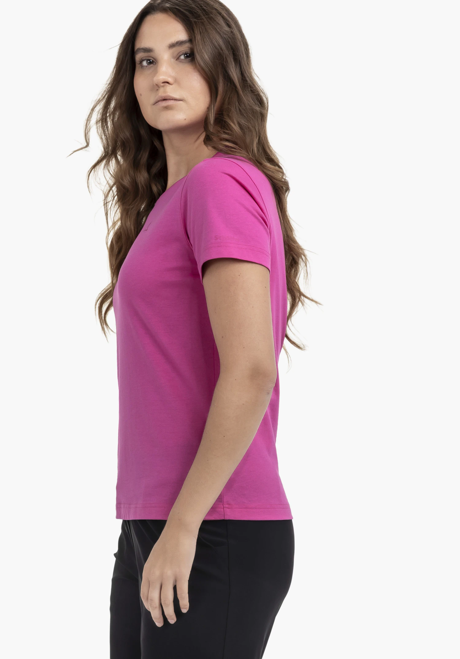 T Shirt Hohberg L in pink, worn by a model standing sideways and looking over her shoulder at the camera. A subtle Schöffel-logo is visible on the sleeve, presented against a neutral background.