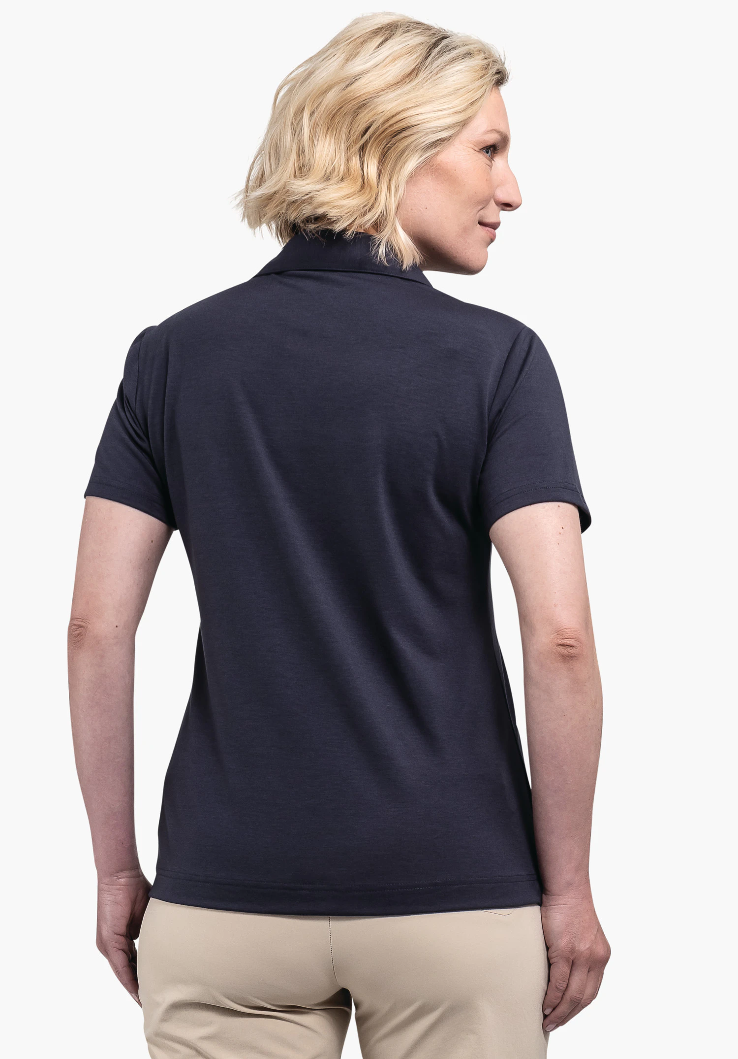 Polo Shirt Ramseck L in Blau vor einem neutralen Hintergrund: Eine Frau in der Rückenansicht präsentiert die Passform des Shirts, während das dezente Schöffel-Logo am Saum platziert ist.