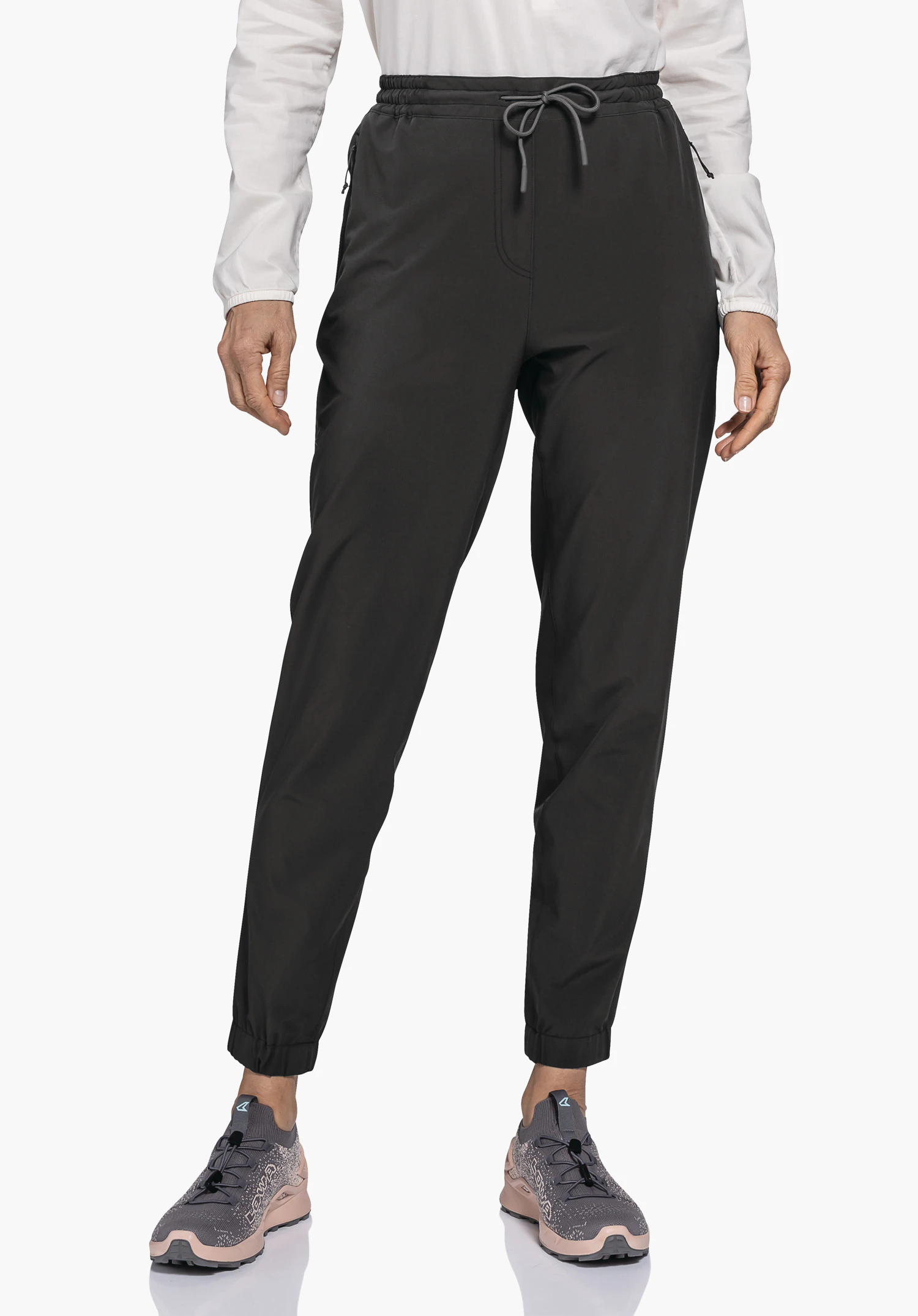 Pants Vienna L getragen von einem Model, das frontal steht. Man sieht die schwarze Hose mit elastischem Bund, Kordelzug und Beinbündchen vor einem neutralen Hintergrund.