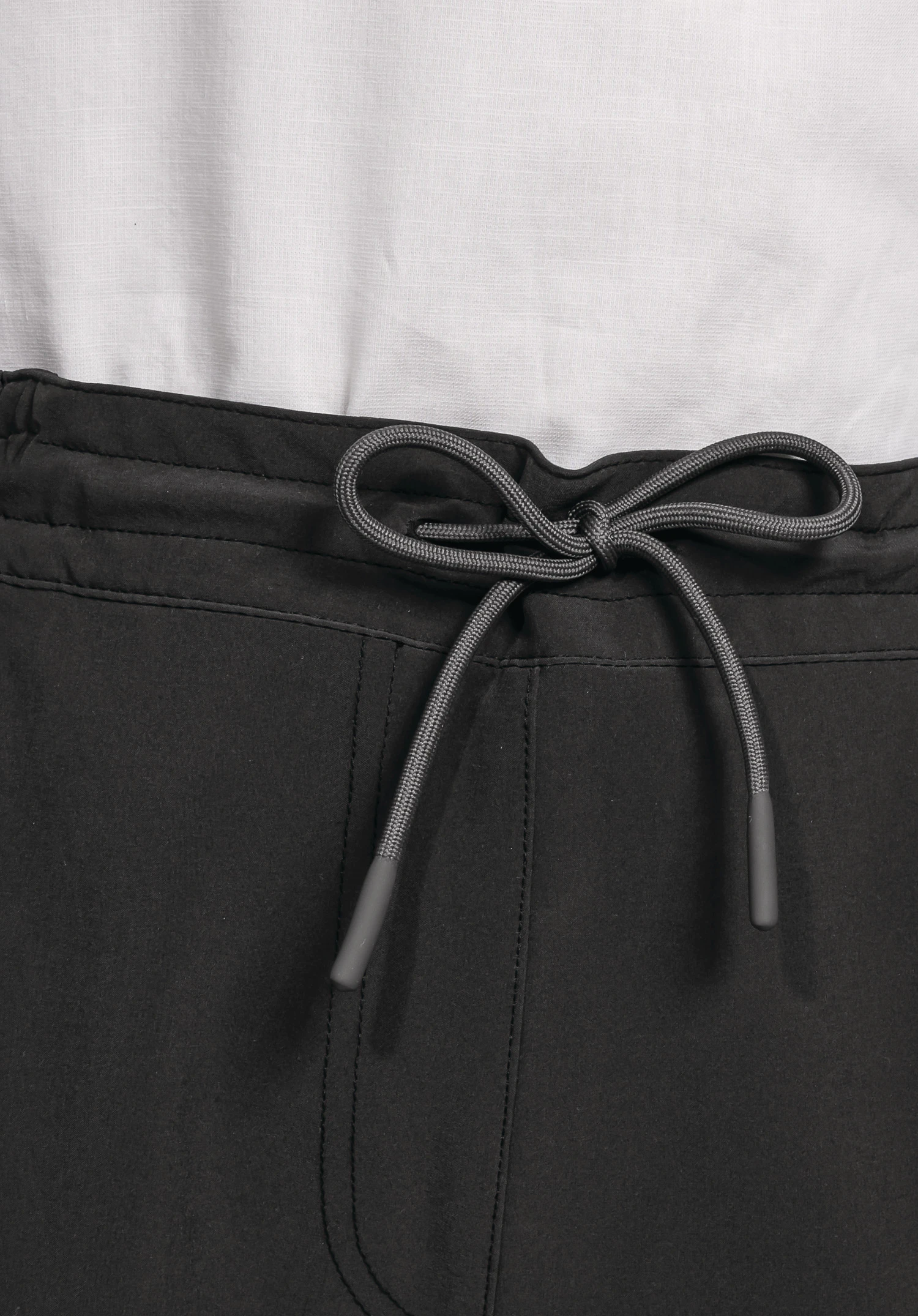 Pants Vienna L, Detailansicht des elastischen Bundes in Schwarz mit einem zu einer Schleife gebundenen Kordelzug. Nahaufnahme vor weißem/neutralem Hintergrund.