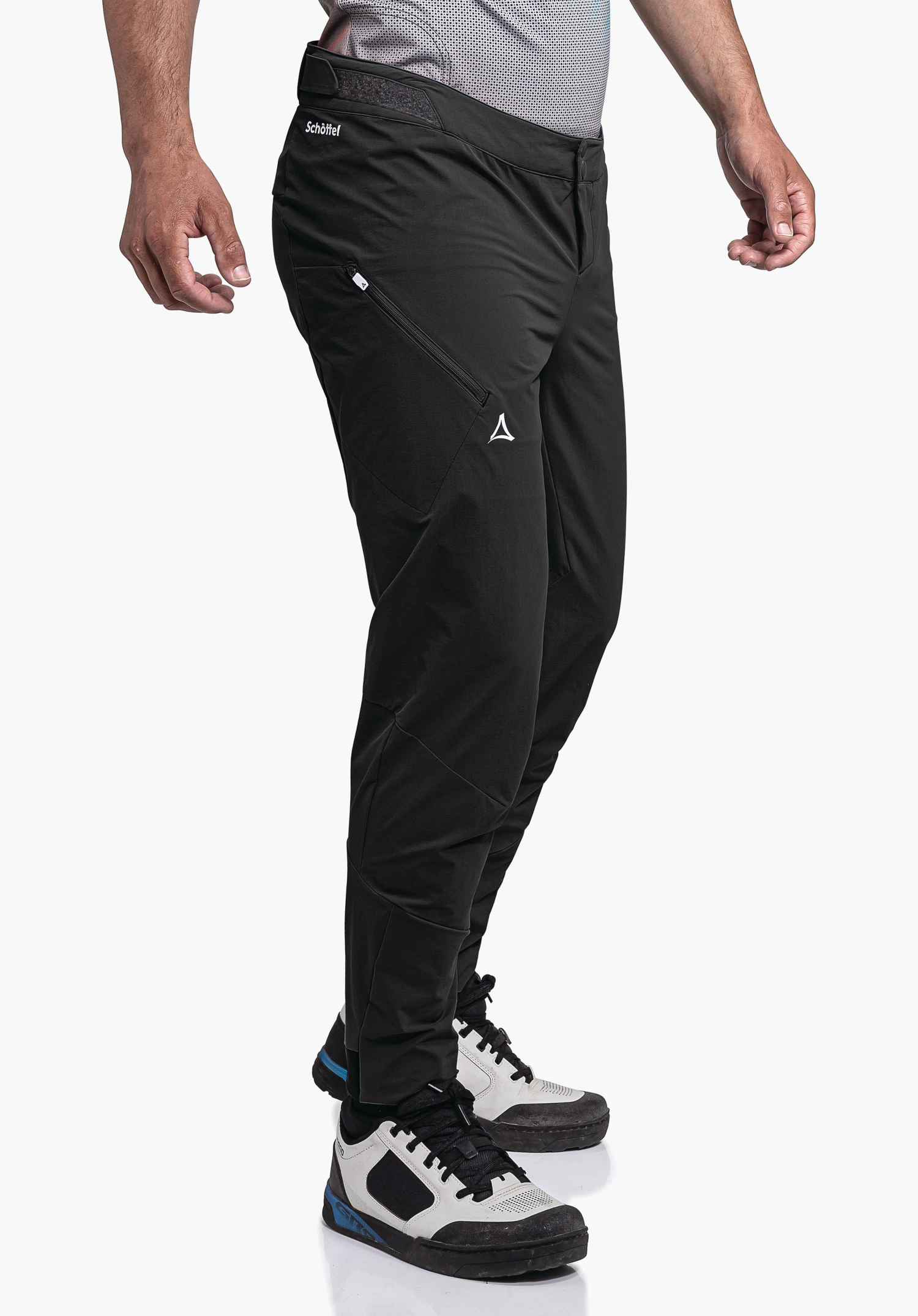 Pants Arosa M pantalon noir porté; personne debout sur fond studio blanc; poche latérale zippée, logo Schöffel sur la cuisse, texte "Schöffel" à la taille.