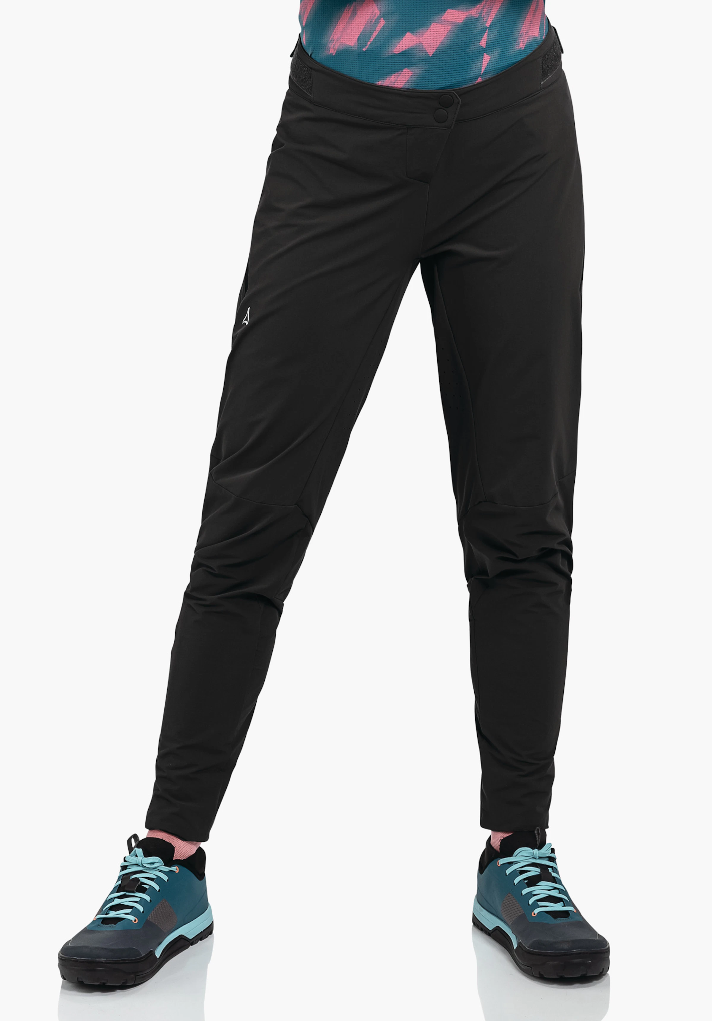 Pants Arosa L black outdoor trousers with Schöffel logo on the outer thigh, worn with legs slightly apart; paired with light blue trekking shoes and pink socks against a white background.