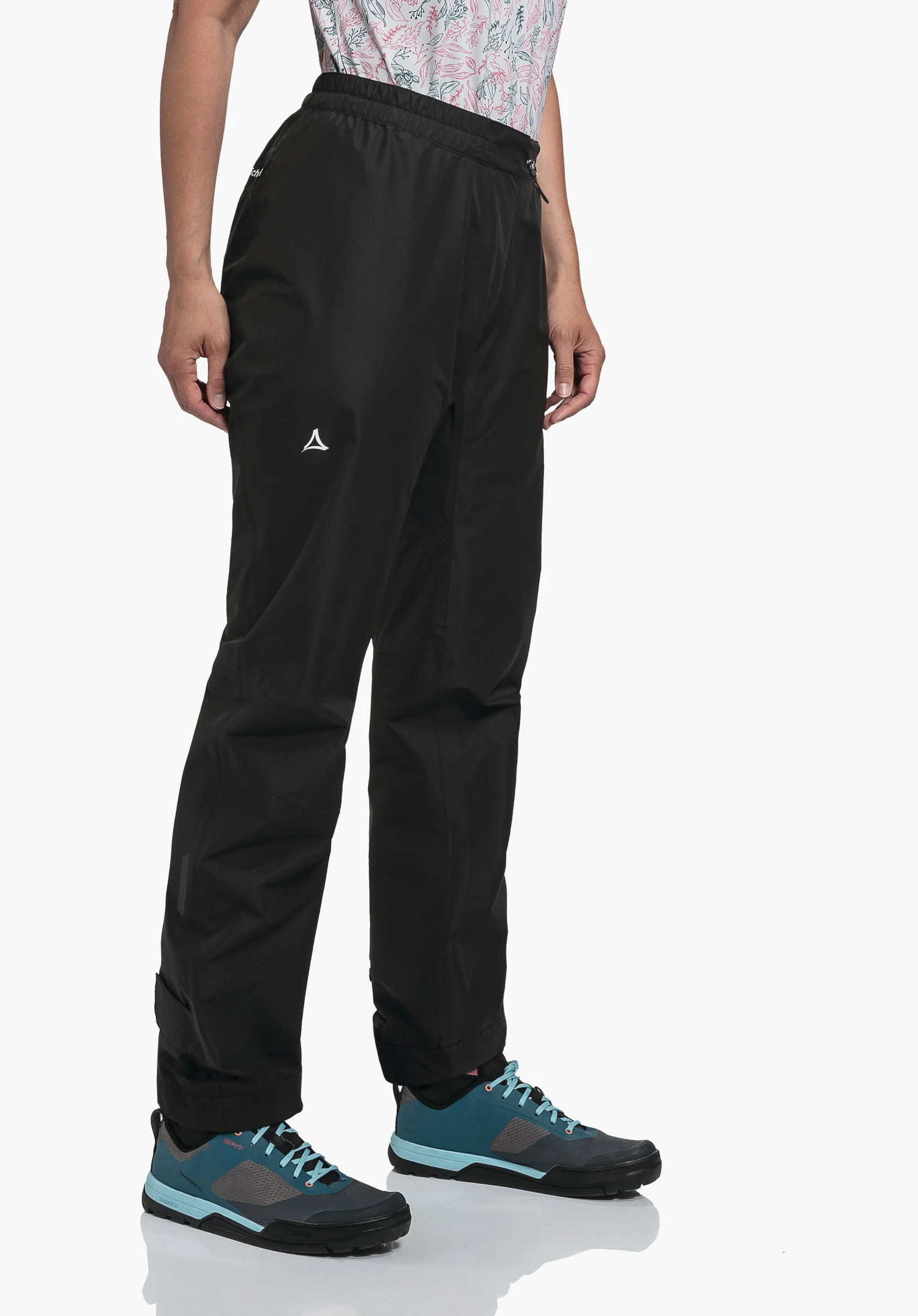 2.5L Pants Tarvis L black trousers worn by a standing person; Schöffel logo on thigh; light background; dark blue shoes with light blue laces.