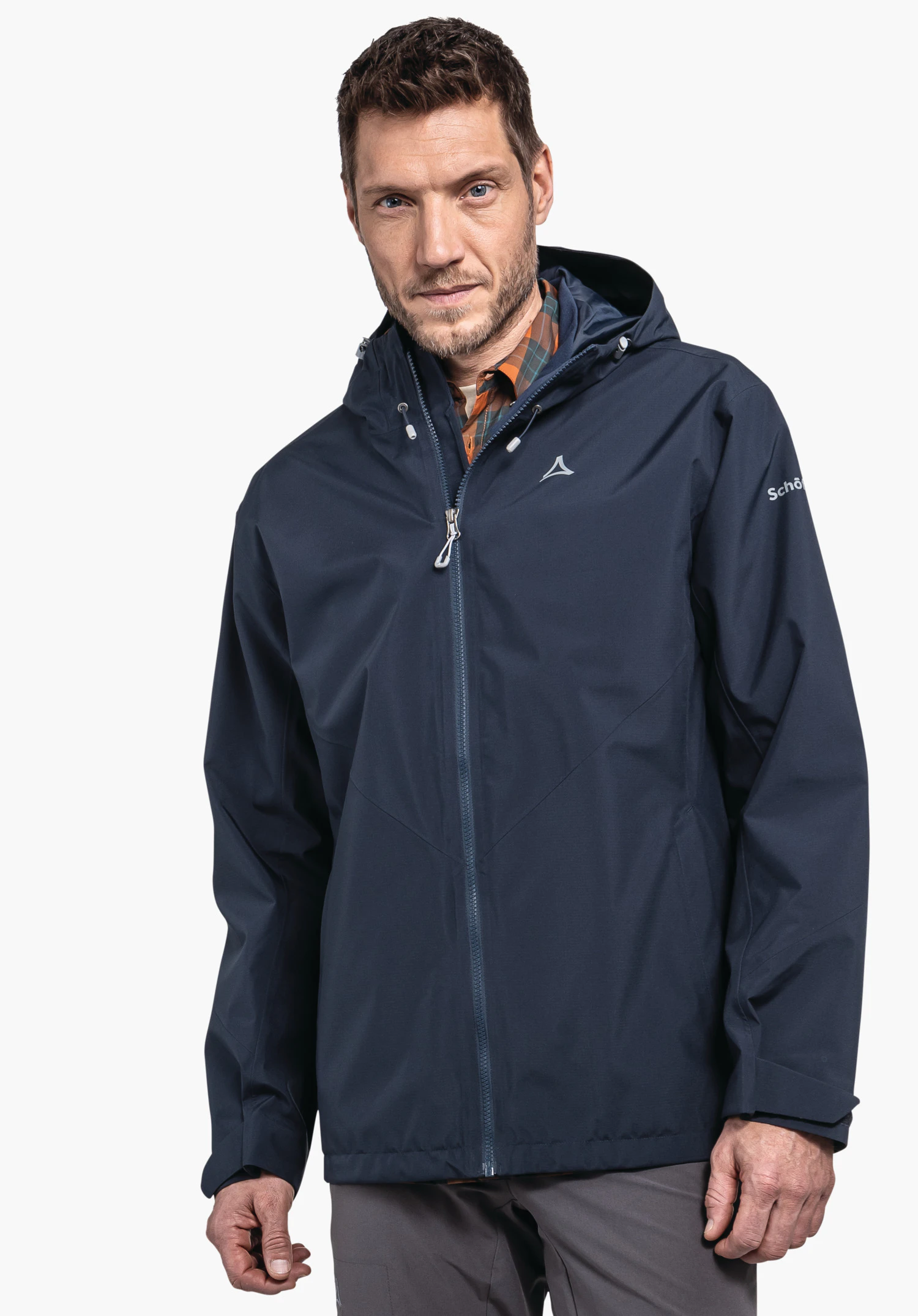 Jacket Style Yew MNS dunkelblau Jacke mit Schöffel-Logo auf der Brust, getragen von einem Mann, der frontal vor weißem Hintergrund steht; Ärmeltext: "Schöffel"