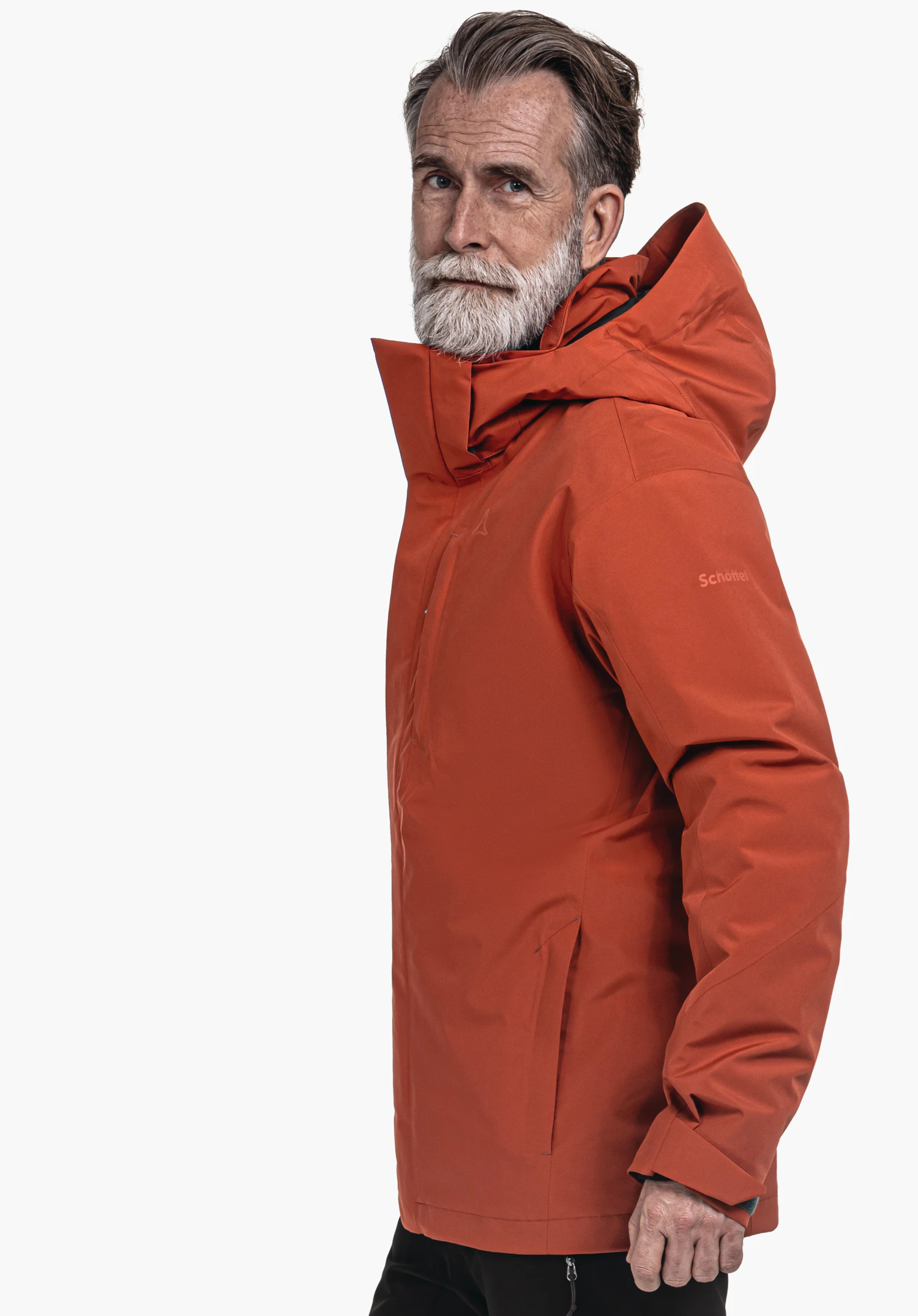 3in1 Jacket Style Tamina MNS Älterer Mann mit weißem Bart trägt orange Kapuzenjacke, blickt seitlich; Jacke zeigt Schöffel-Logo und Schriftzug 'Schöffel', weißer Hintergrund.
