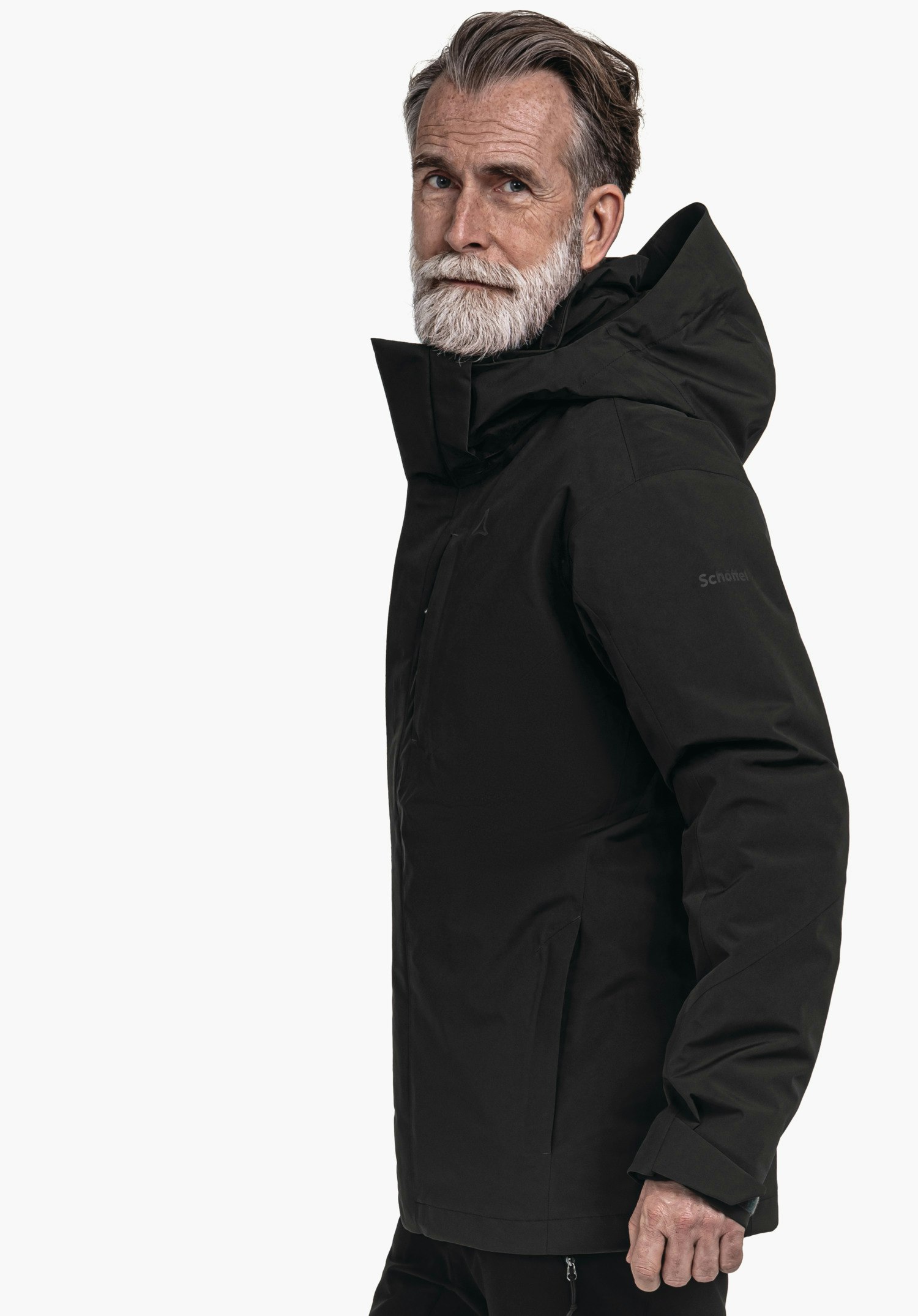 3in1 Jacket Style Tamina MNS Schwarze Outdoorjacke, ein älterer Mann trägt sie und schaut seitlich zur Kamera; Schöffel-Logo auf der Brust, Schriftzug "Schöffel" am Ärmel, weißer Hintergrund.