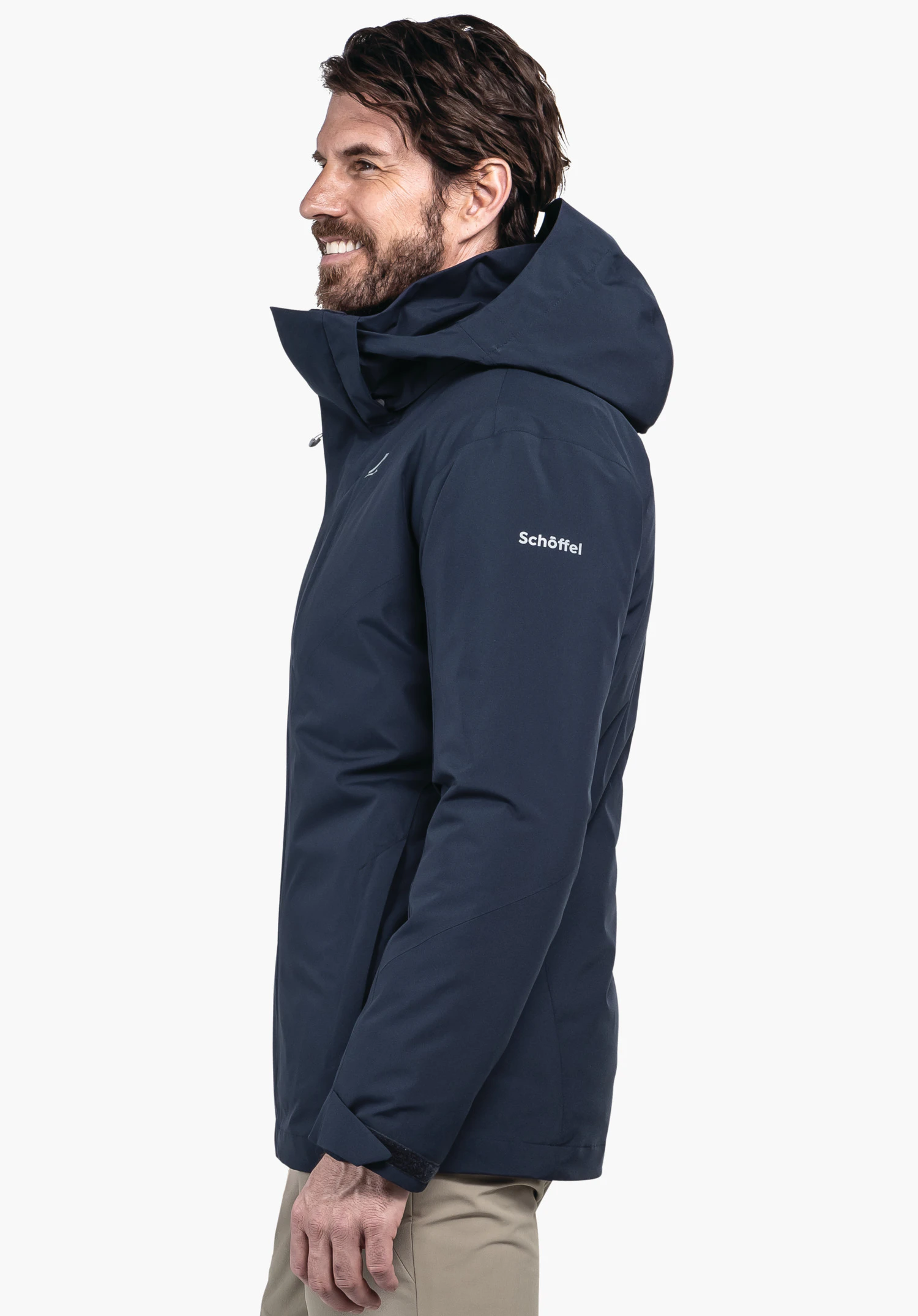 3in1 Jacket Style Tamina MNS dark blue jacket worn side-on by a smiling man; hood raised; context: neutral light background. Text on garment: "Schöffel". Schöffel logo visible.